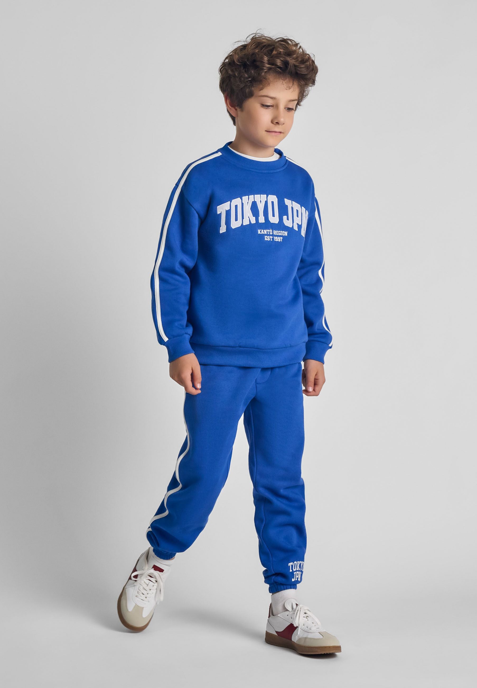 Boys cobalt blue sweatshirt and joggers set, front view, featuring 'TOKYO JPN' print and side tape detail.