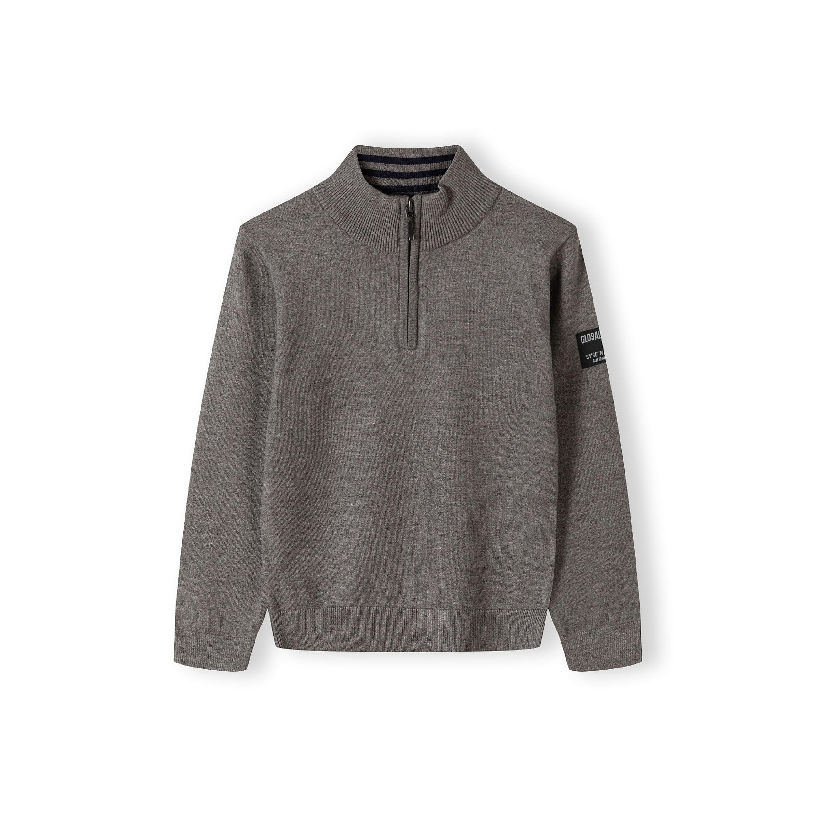 Front view of grey half zip jumper with stand collar and zip closure, showing ribbed details and arm badge