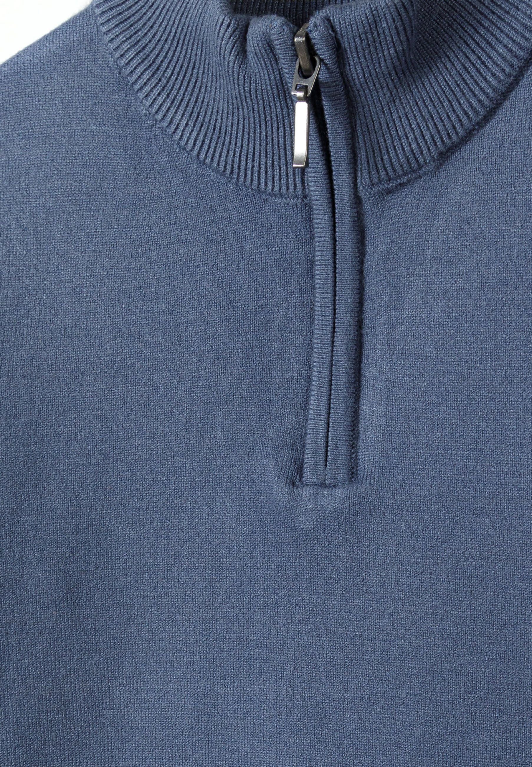 Close-up of a boys' blue jumper with half zip and ribbed cuffs.