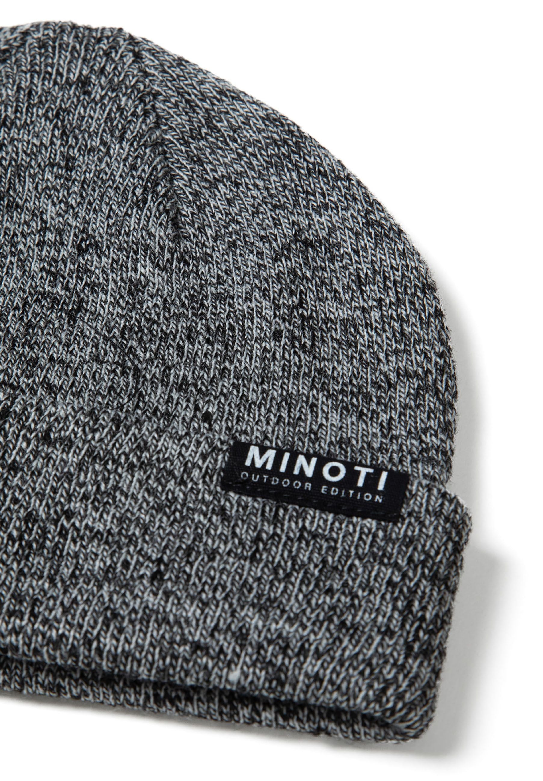 Detail of a grey knitted beanie with ribbed cuff and badge.