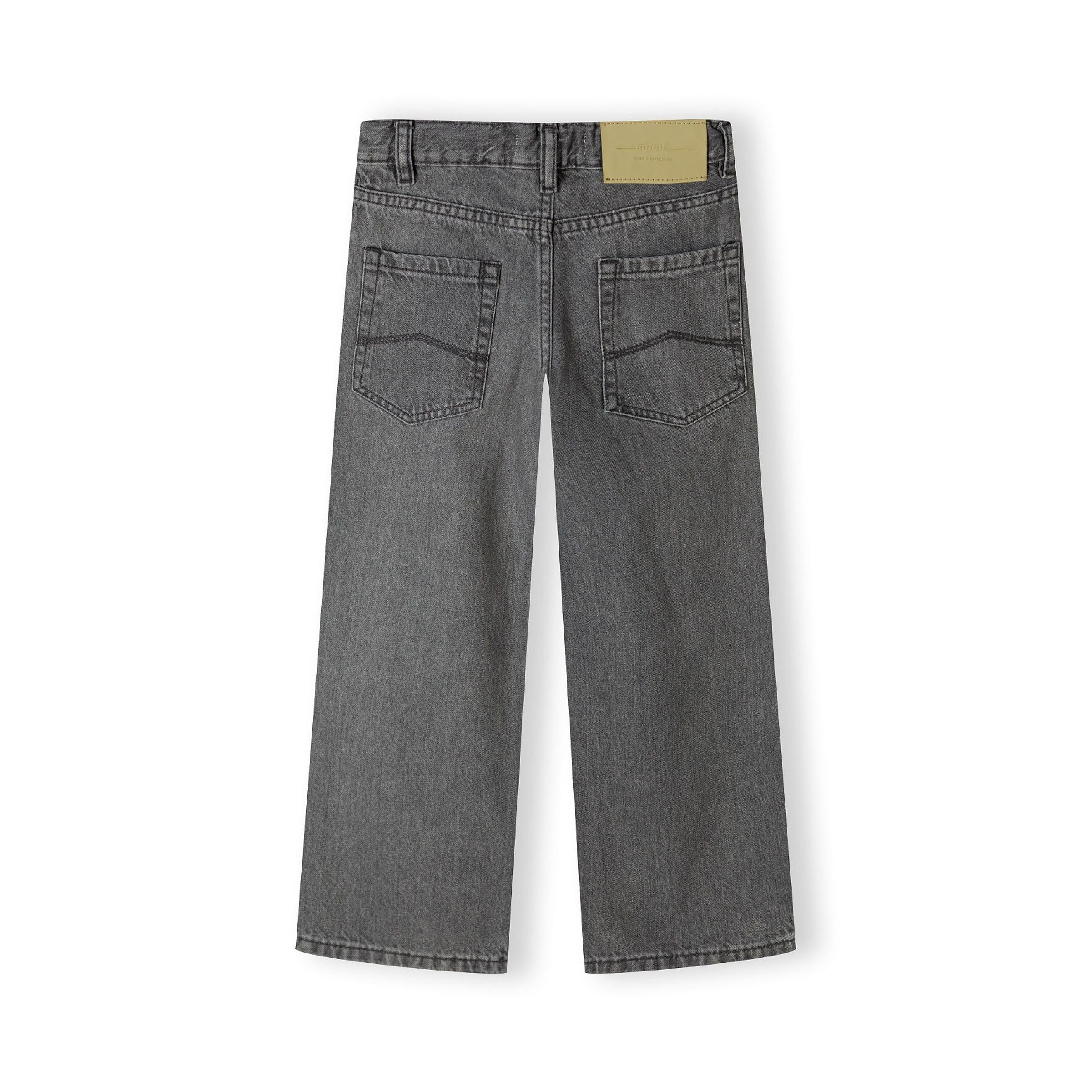 Flat lay of grey baggy jeans showing back view with traditional 5-pocket design, belt loops and branded label on white background
