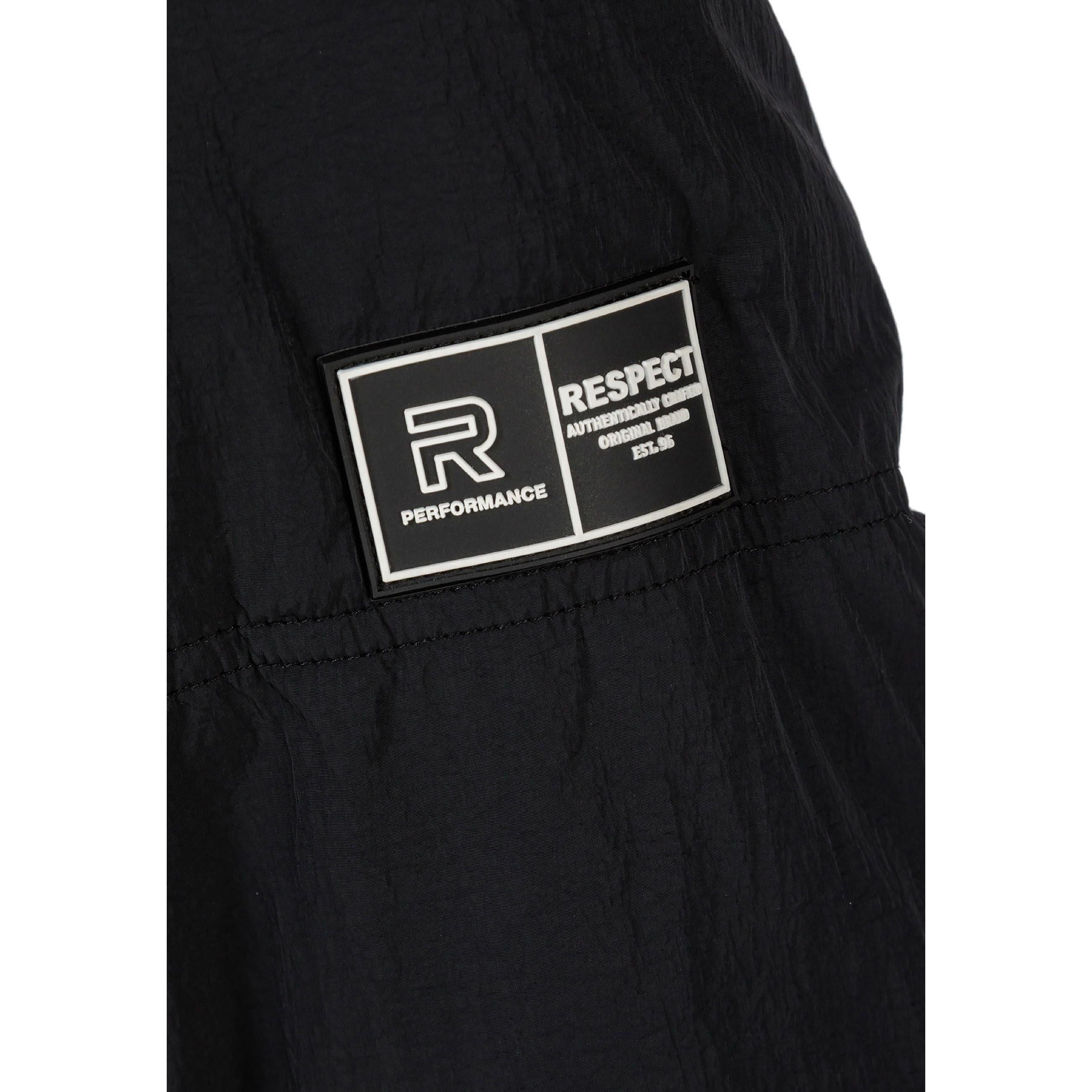 Close-up detail of black quilted fabric showing rectangular RESPECT PERFORMANCE brand label with R logo on jacket sleeve
