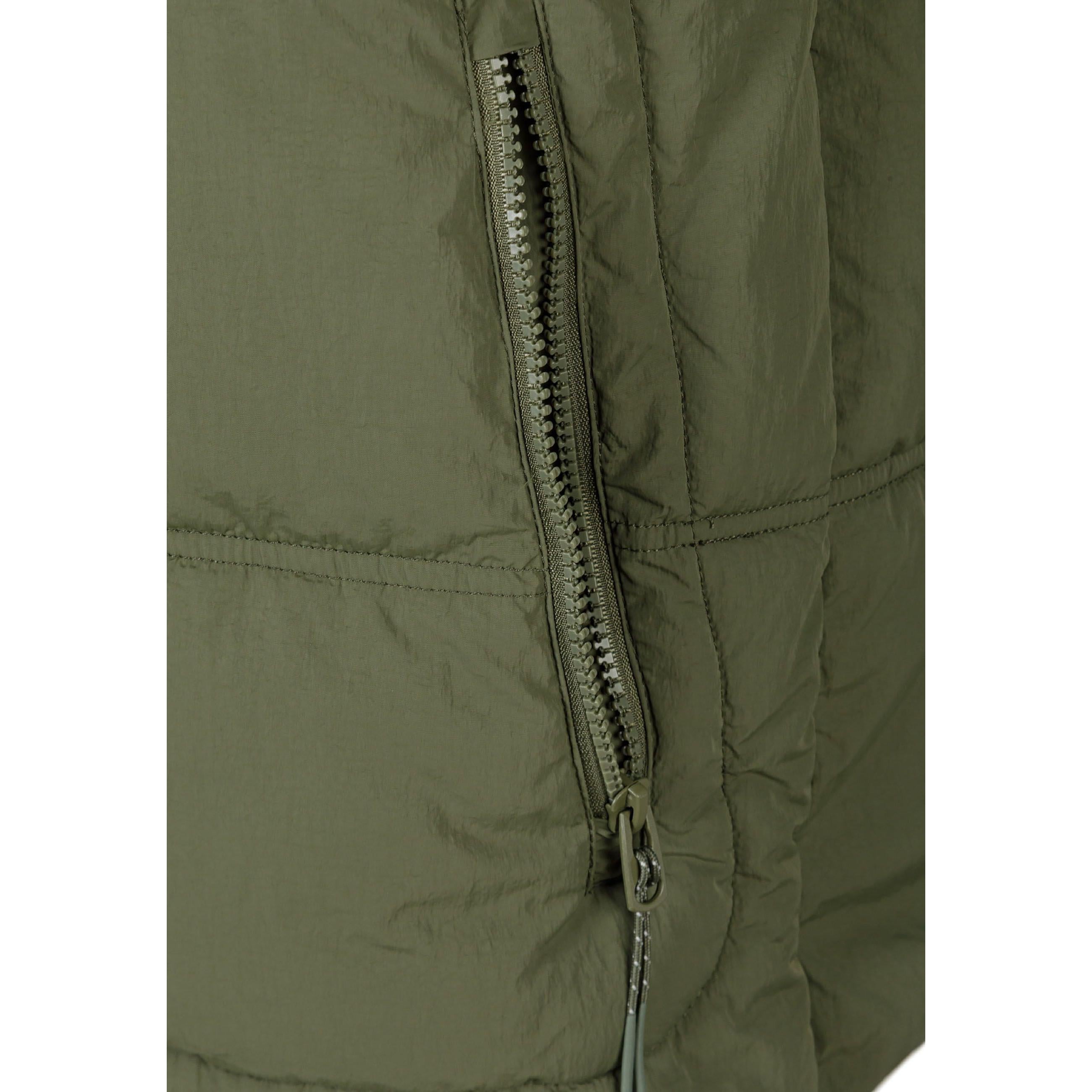 Close-up detail of black rectangular brand patch with 'R PERFORMANCE' and 'RESPECT' text on khaki fabric