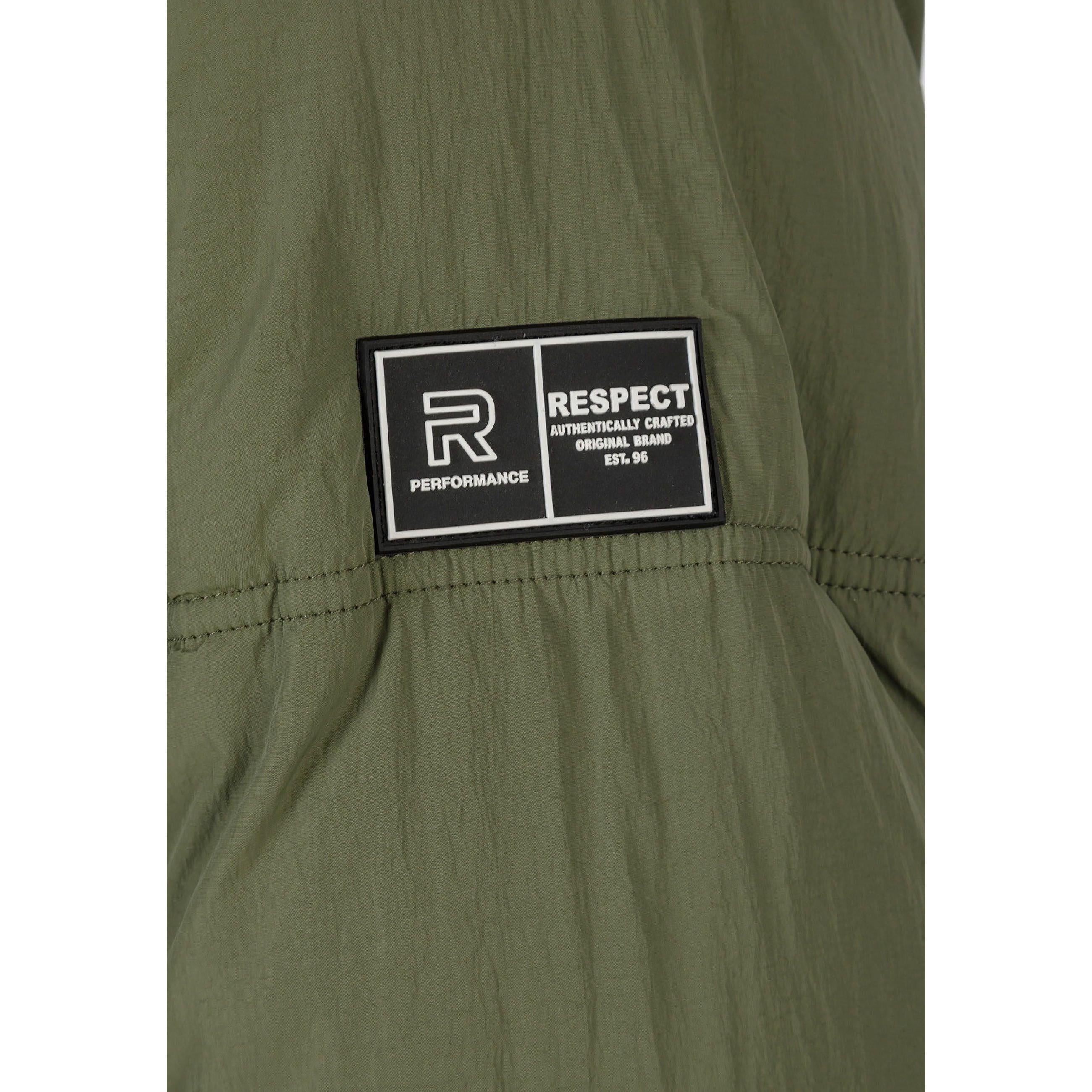 Close-up detail of black rectangular brand patch with 'R PERFORMANCE' and 'RESPECT' text on khaki fabric