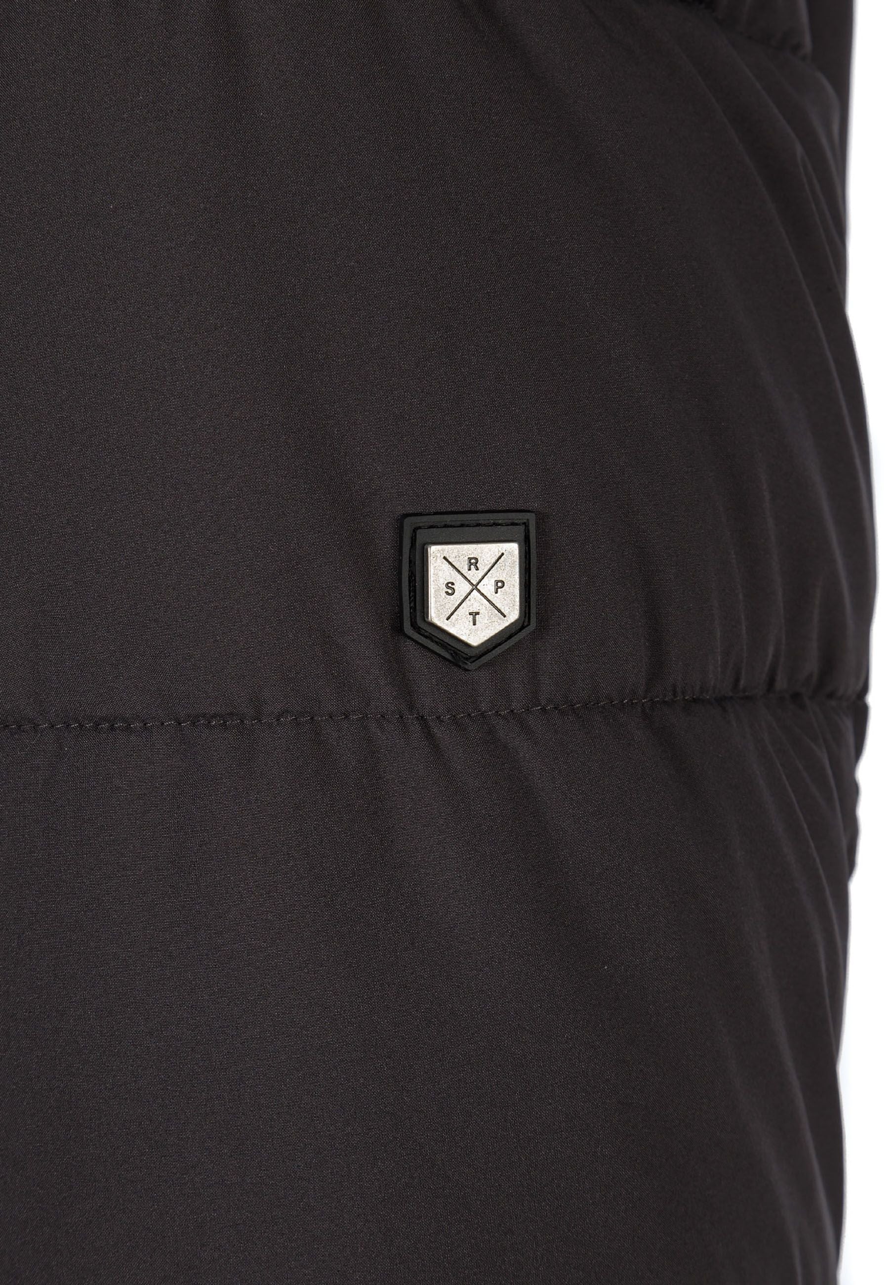 Detail of a men's long jacket featuring a logo badge.