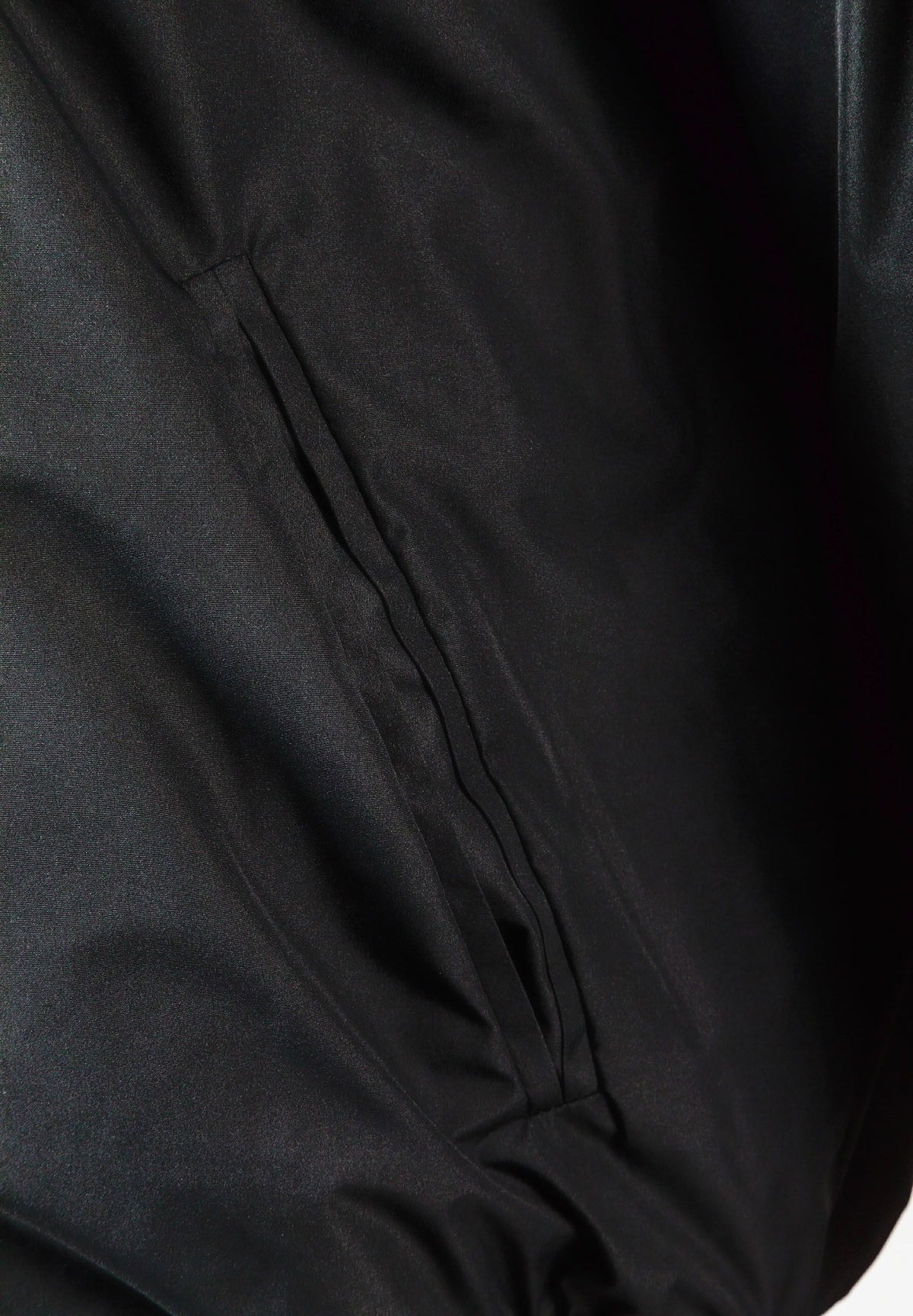 Close-up of the side pocket on the black varsity jacket.