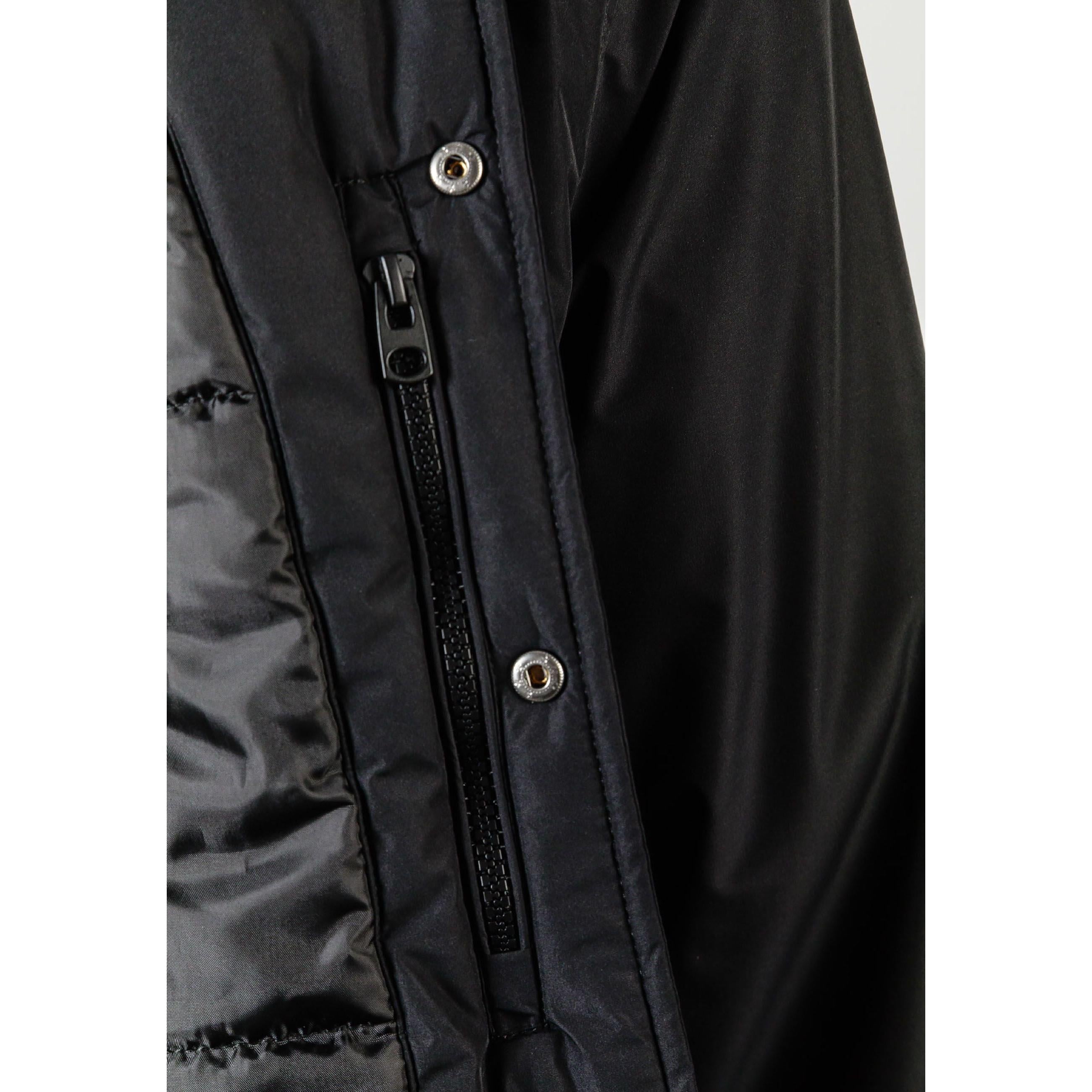 Close-up detail of black jacket showing zip closure with press studs and fabric texture