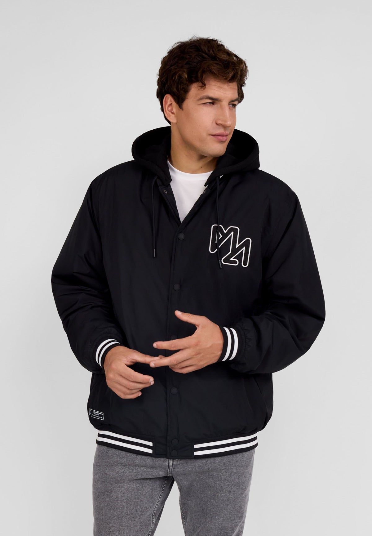 Men's black varsity jacket, shown worn.