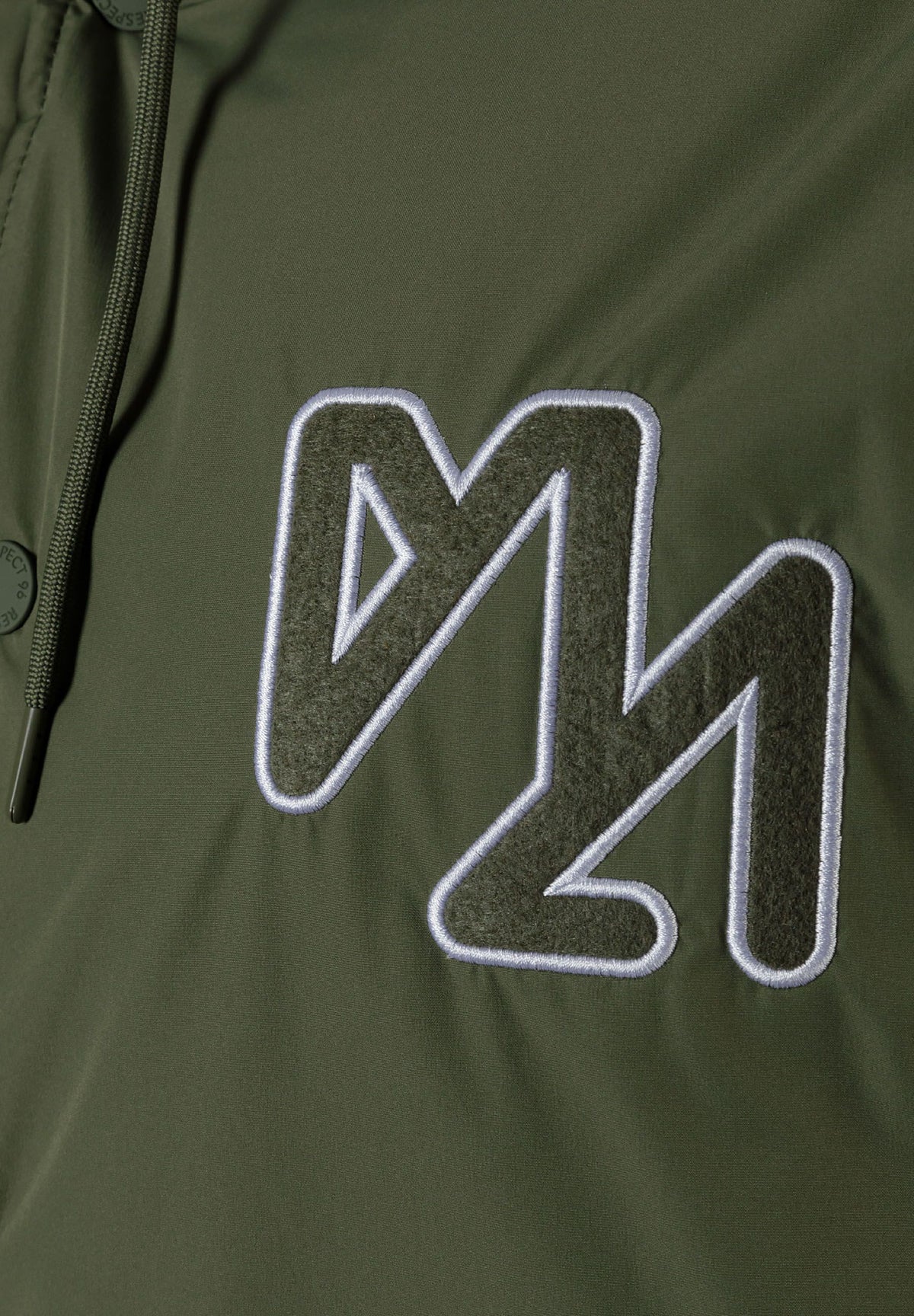 Close-up of the chest on the khaki varsity jacket.