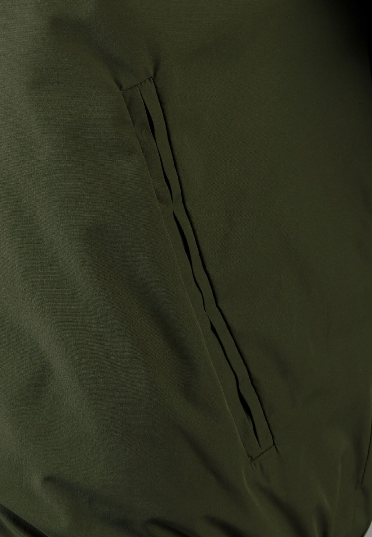 Close-up of the side pocket on the khaki varsity jacket.
