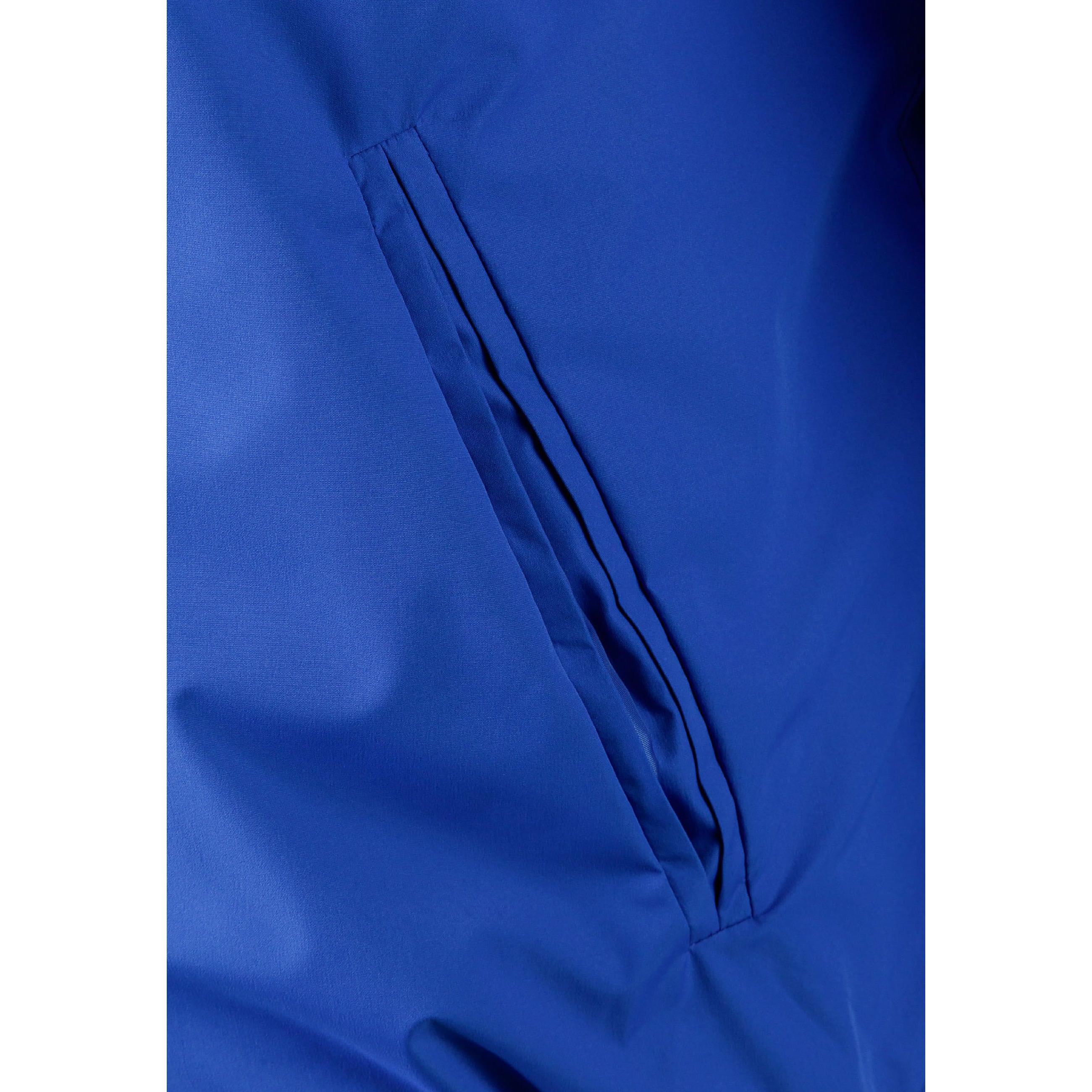 Close-up detail of cobalt blue jacket showing zip closure with matching blue zipper tape and snap button details