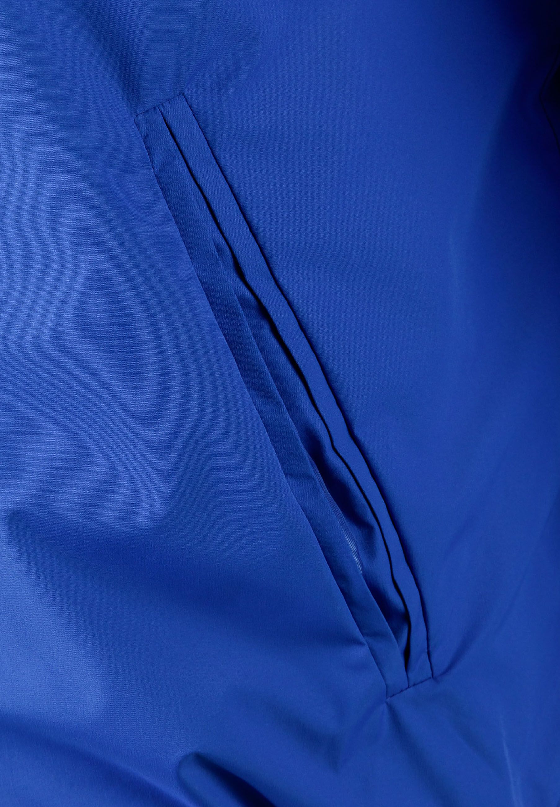 Detail of a cobalt blue men's baseball jacket showing a zippered pocket.