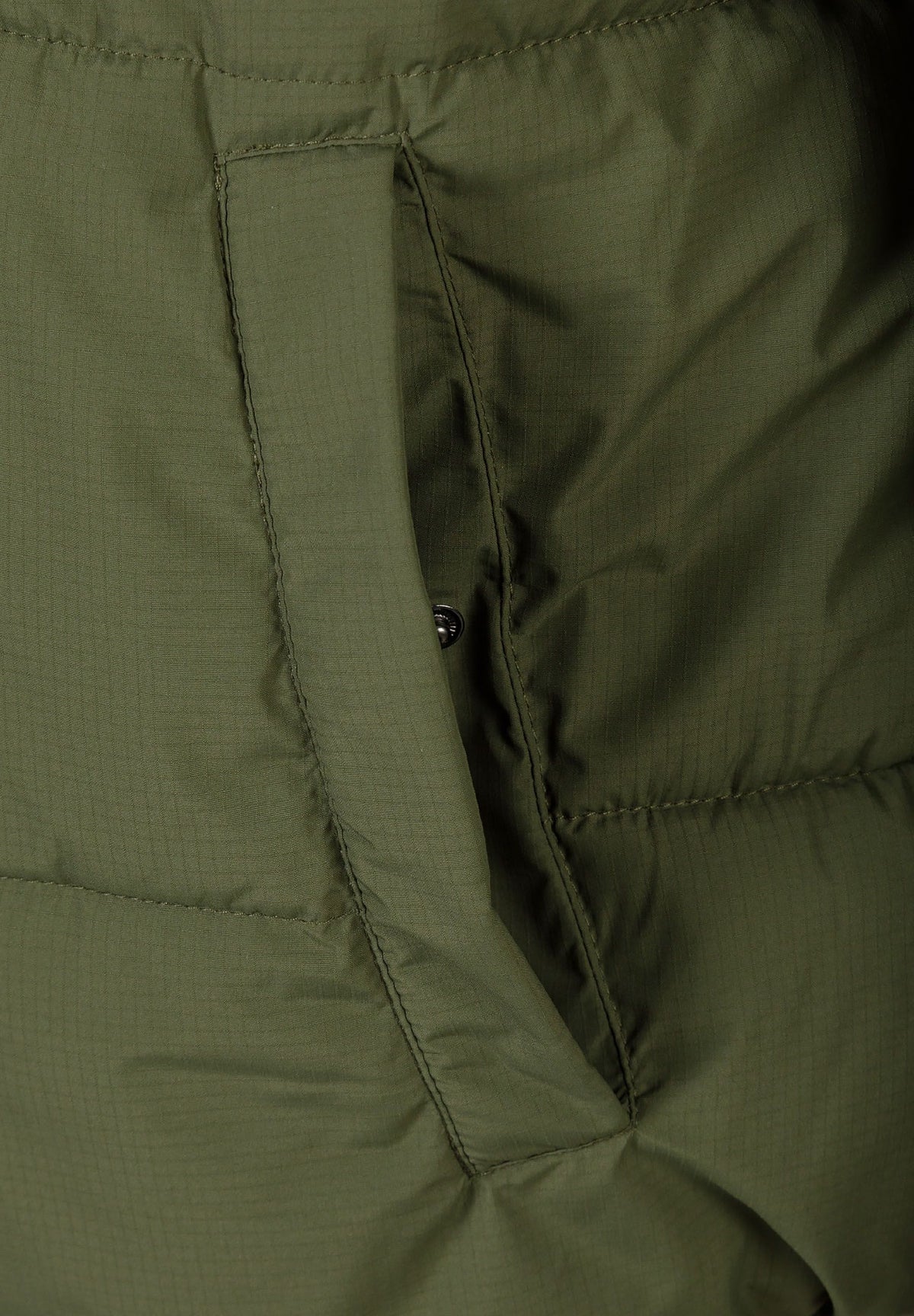 Close-up of the pocket on the khaki puffer jacket.