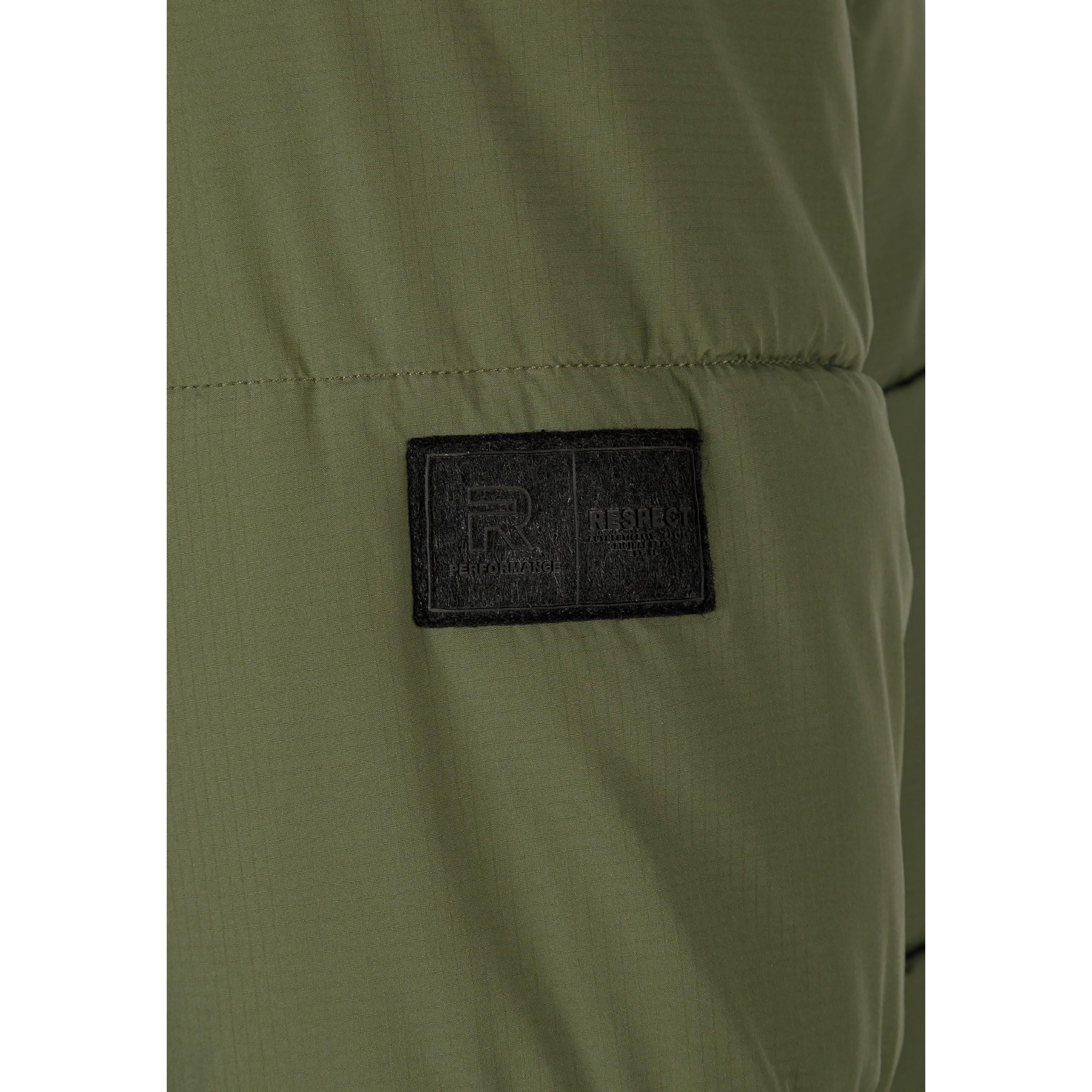 Close-up detail of black rectangular brand patch on khaki quilted jacket sleeve