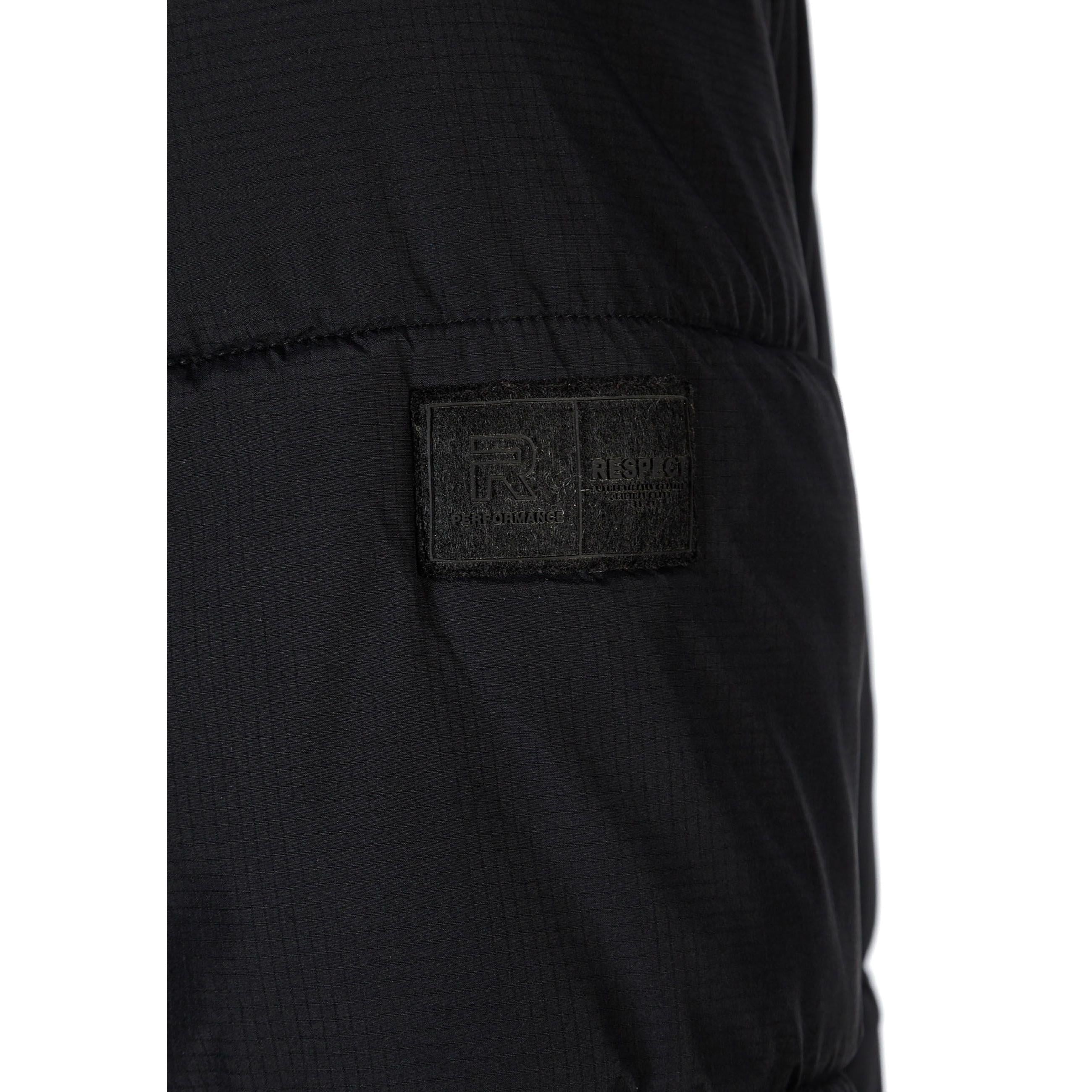 Close up detail of black fabric label patch on sleeve showing textured ripstop material