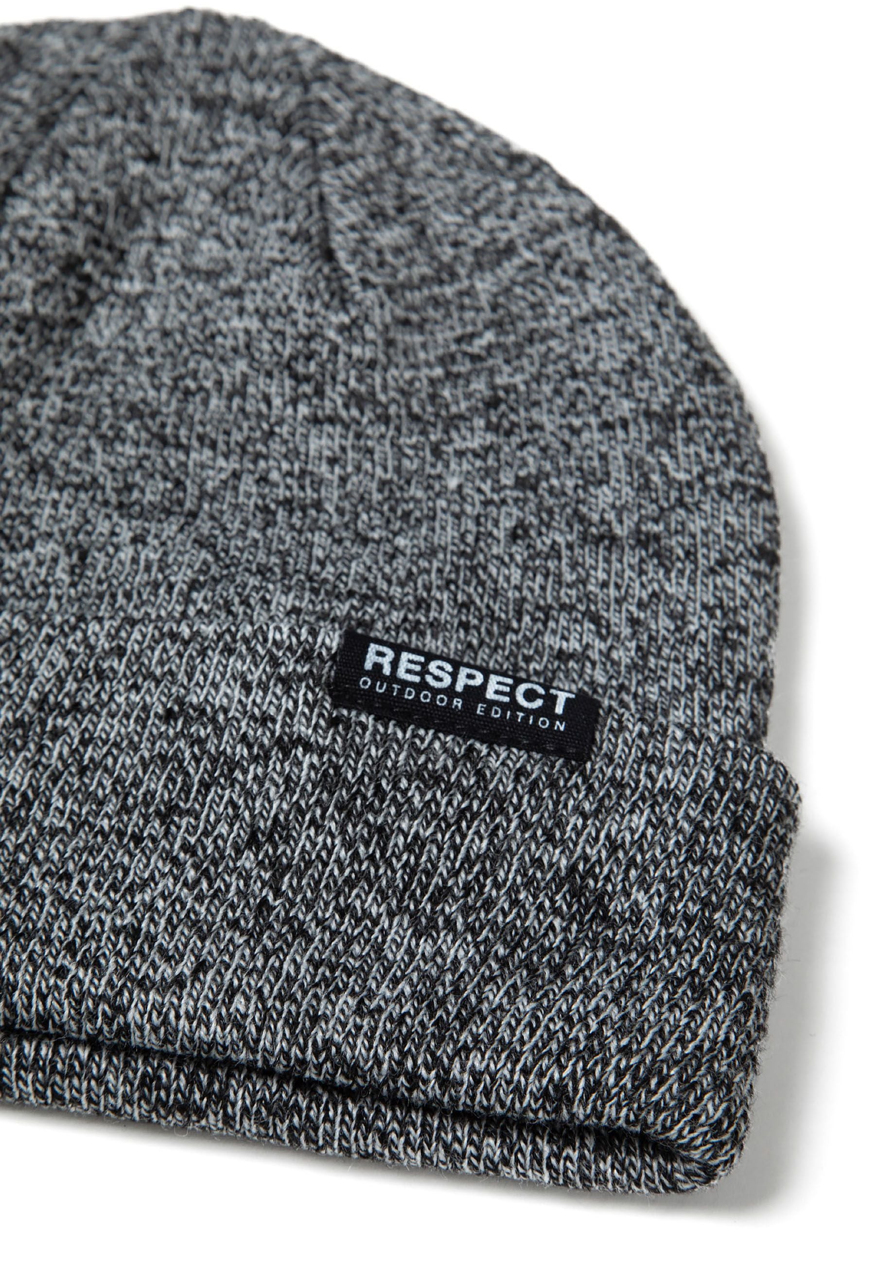 Close-up of a grey knit beanie with a fold-up hem and logo badge.