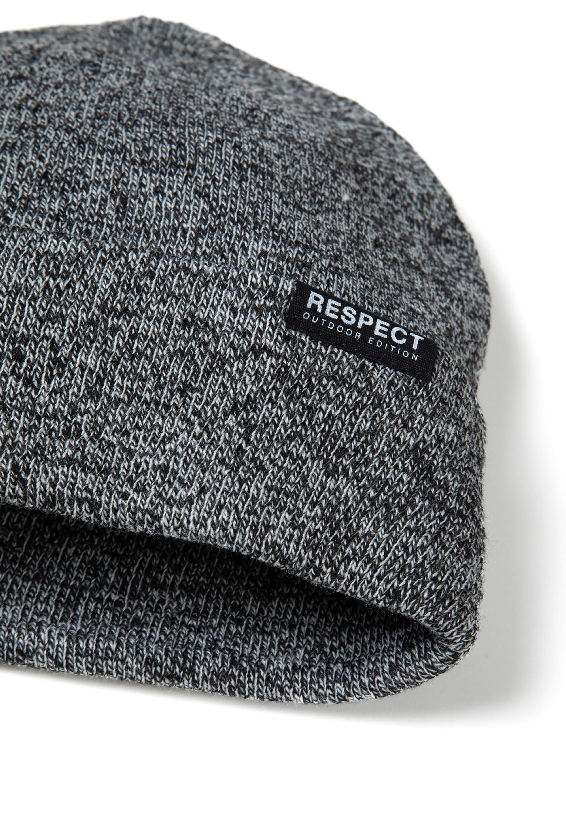 Close-up of a grey knit beanie with a fold-up hem and logo badge.