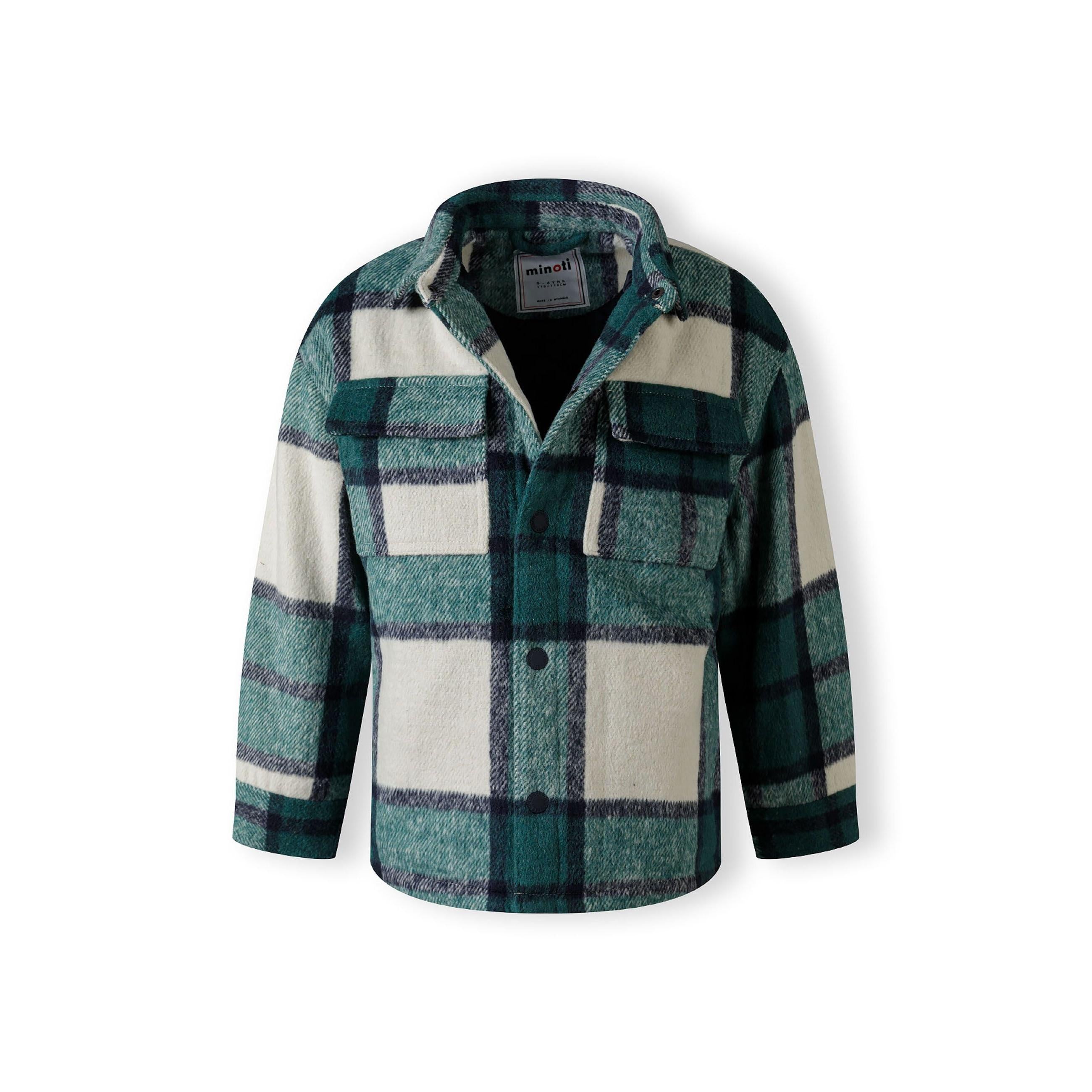 Close-up detail of green check shirt jacket showing chest pocket, button placket and quilted fabric texture with plaid pattern