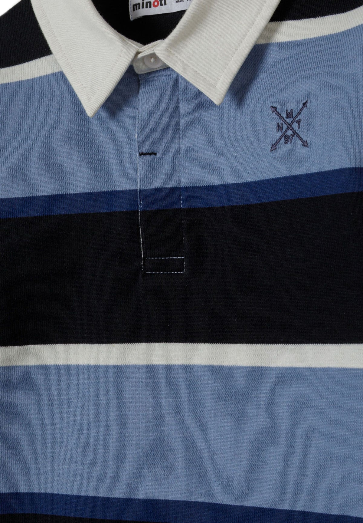 Close-up of rugby shirt's white pointed collar, covered button placket and navy chest emblem.