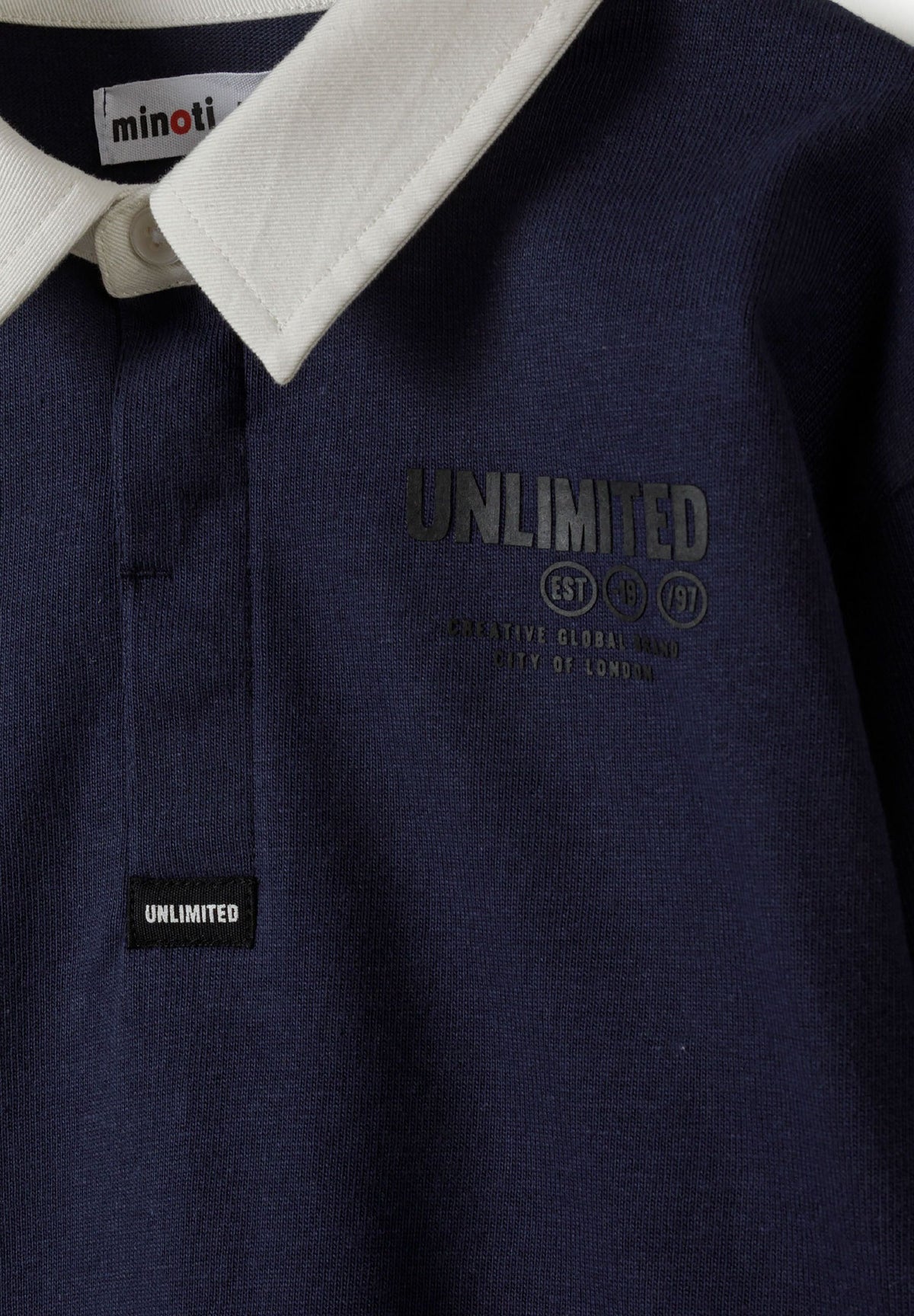 Close-up of white rugby collar, concealed navy placket and dark Unlimited chest print on navy fabric.