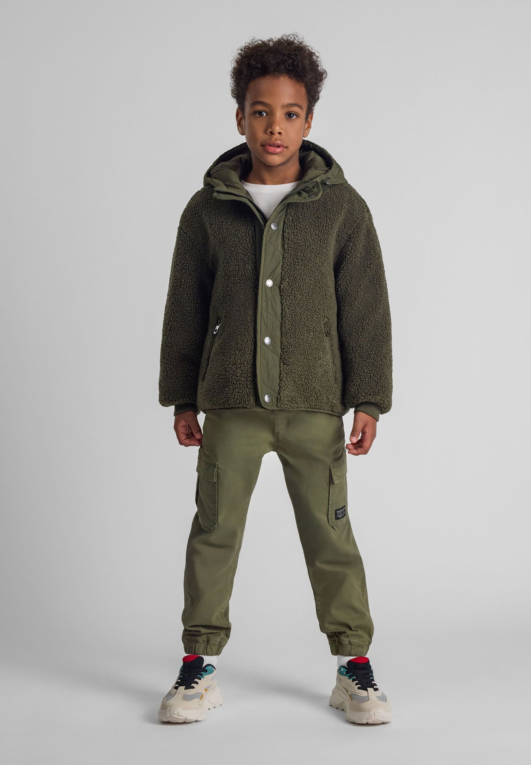 Boys khaki cargo trousers with elastic waist, side pockets, and ankle cuffs, front view.