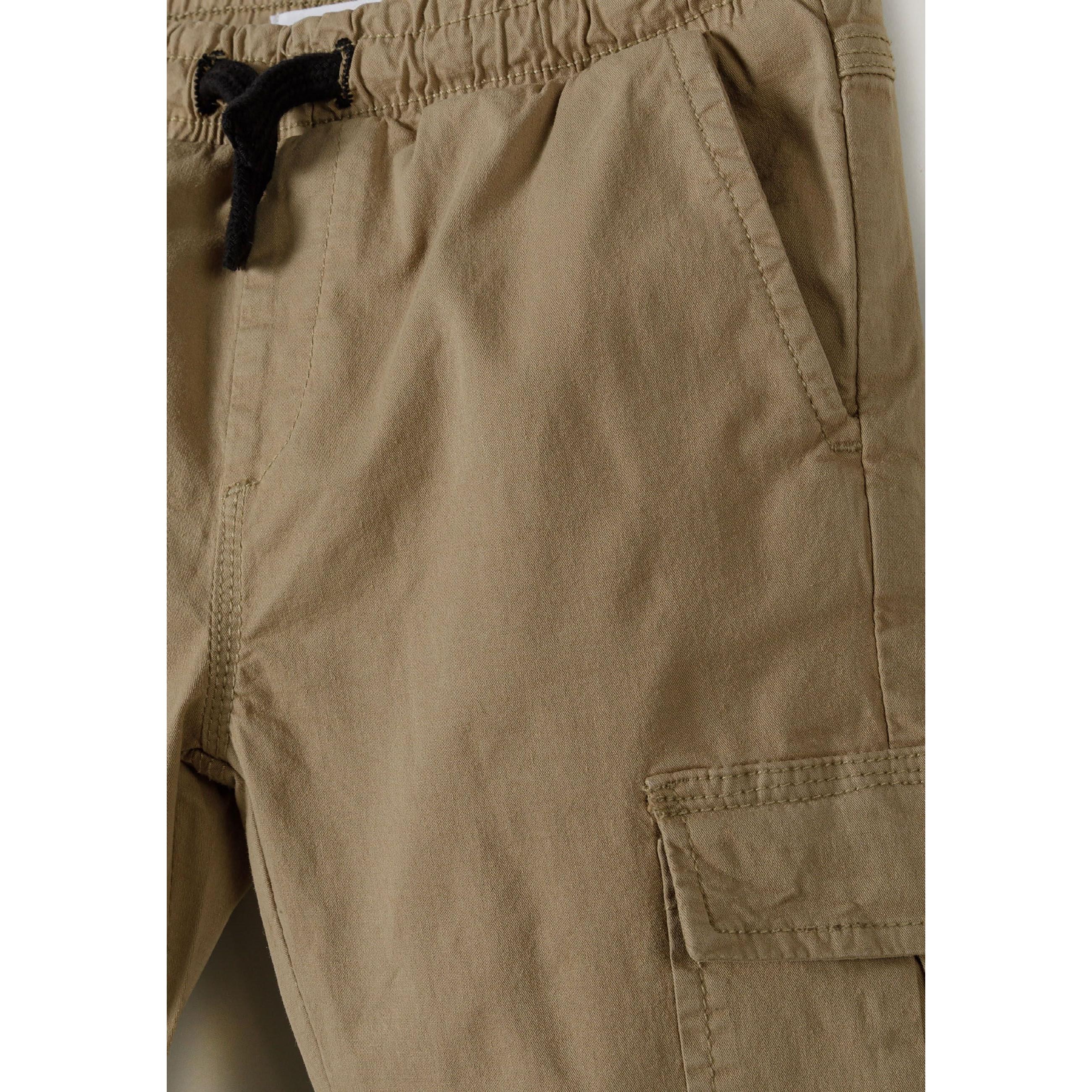 Close-up detail of grey cargo trousers showing elasticated waistband with black drawstring and cargo pocket on side