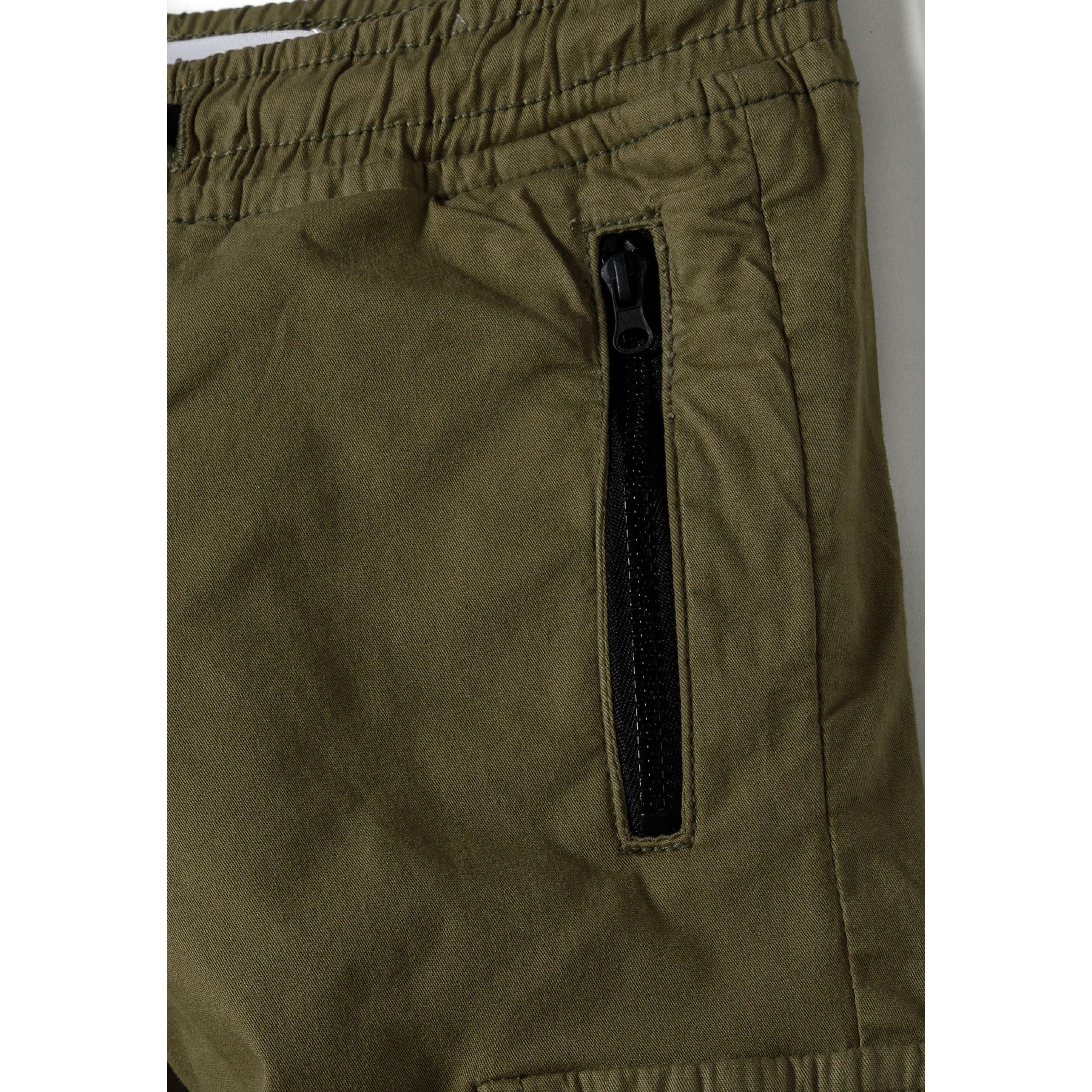Close-up detail of olive green cargo trousers showing zip pocket with black zipper and elasticated waistband construction