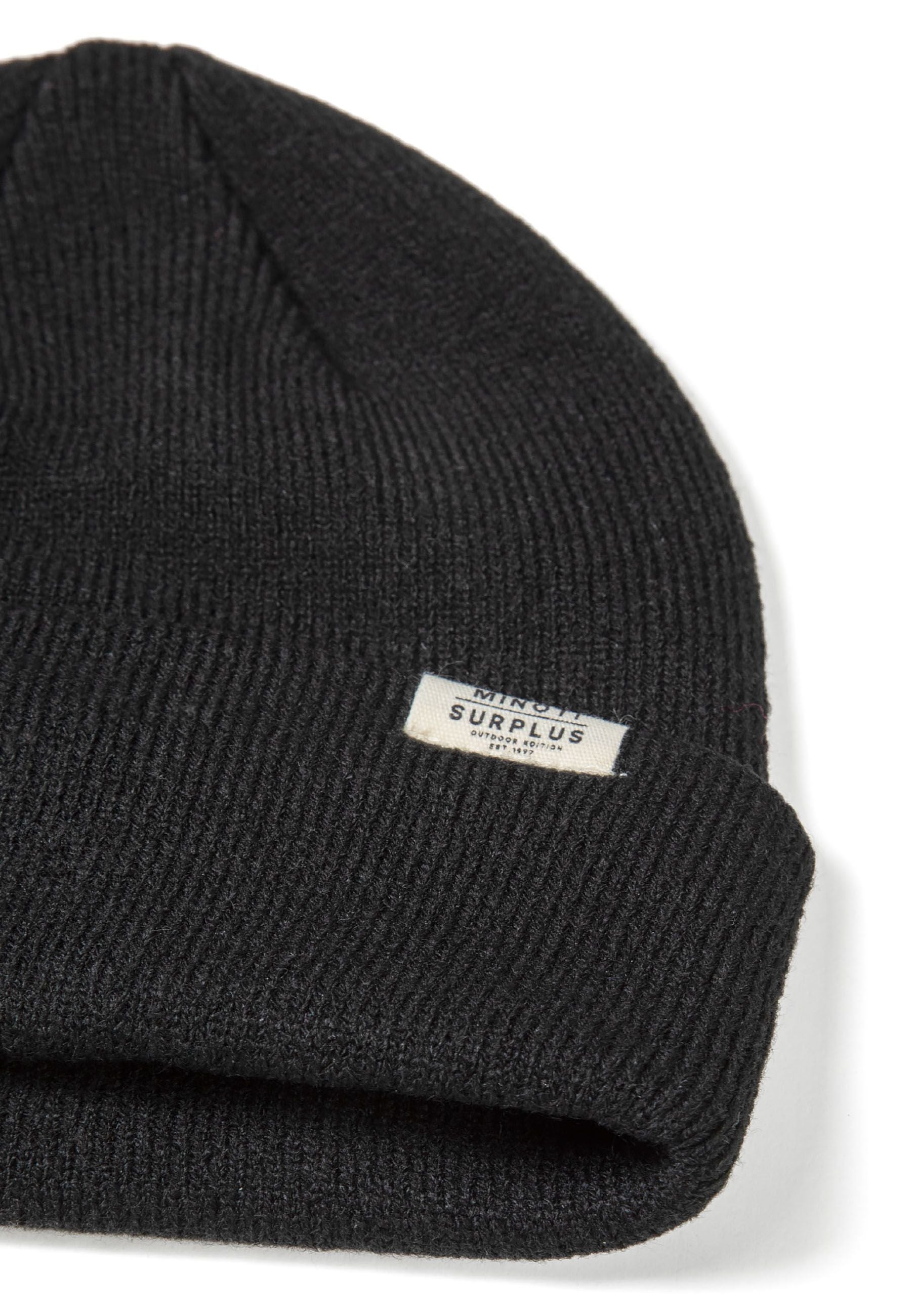 Close-up of a black ribbed beanie hat with a fold-up cuff and a subtle logo badge.