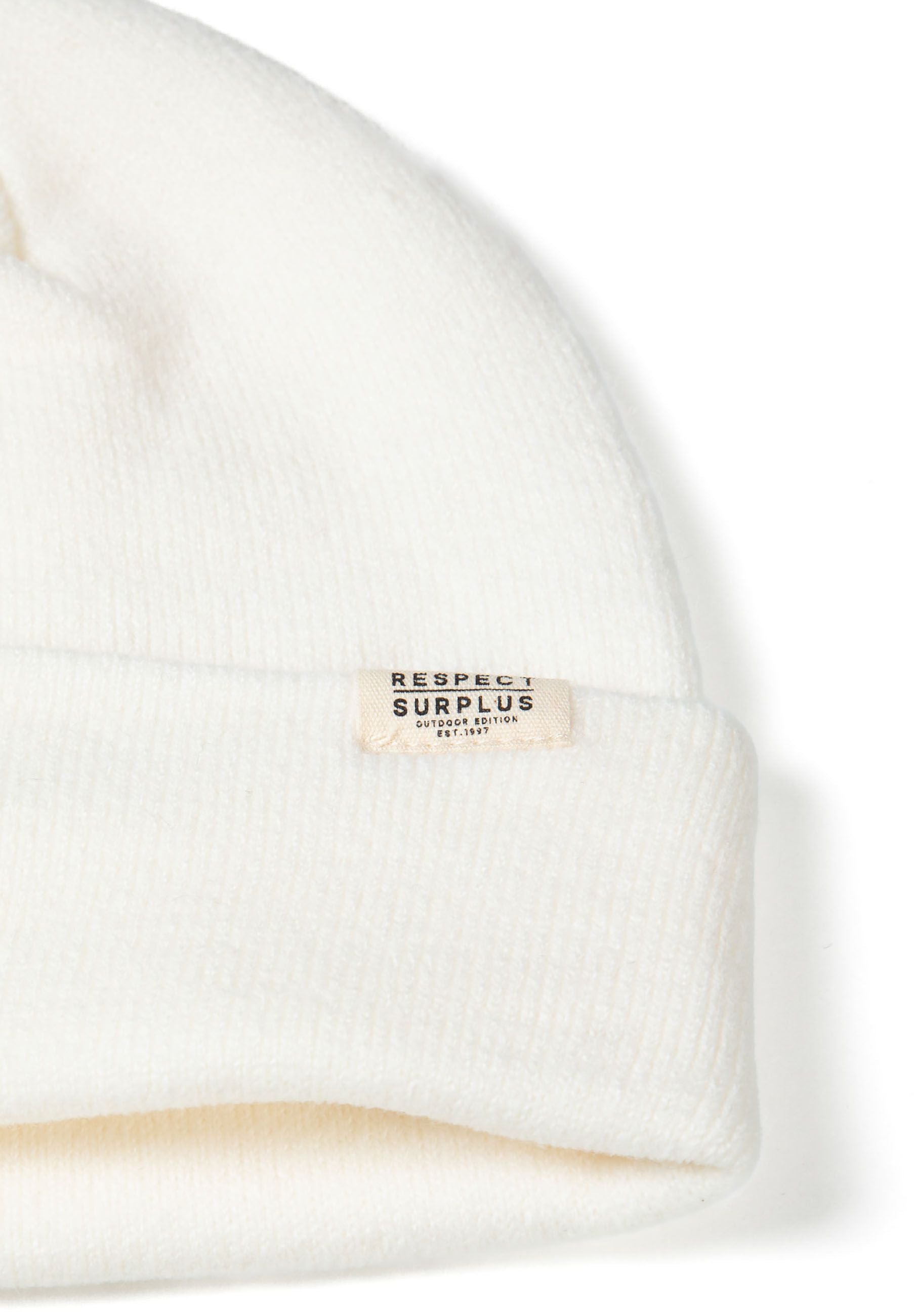 Detail of a white ribbed beanie hat with a cuff and a logo badge.