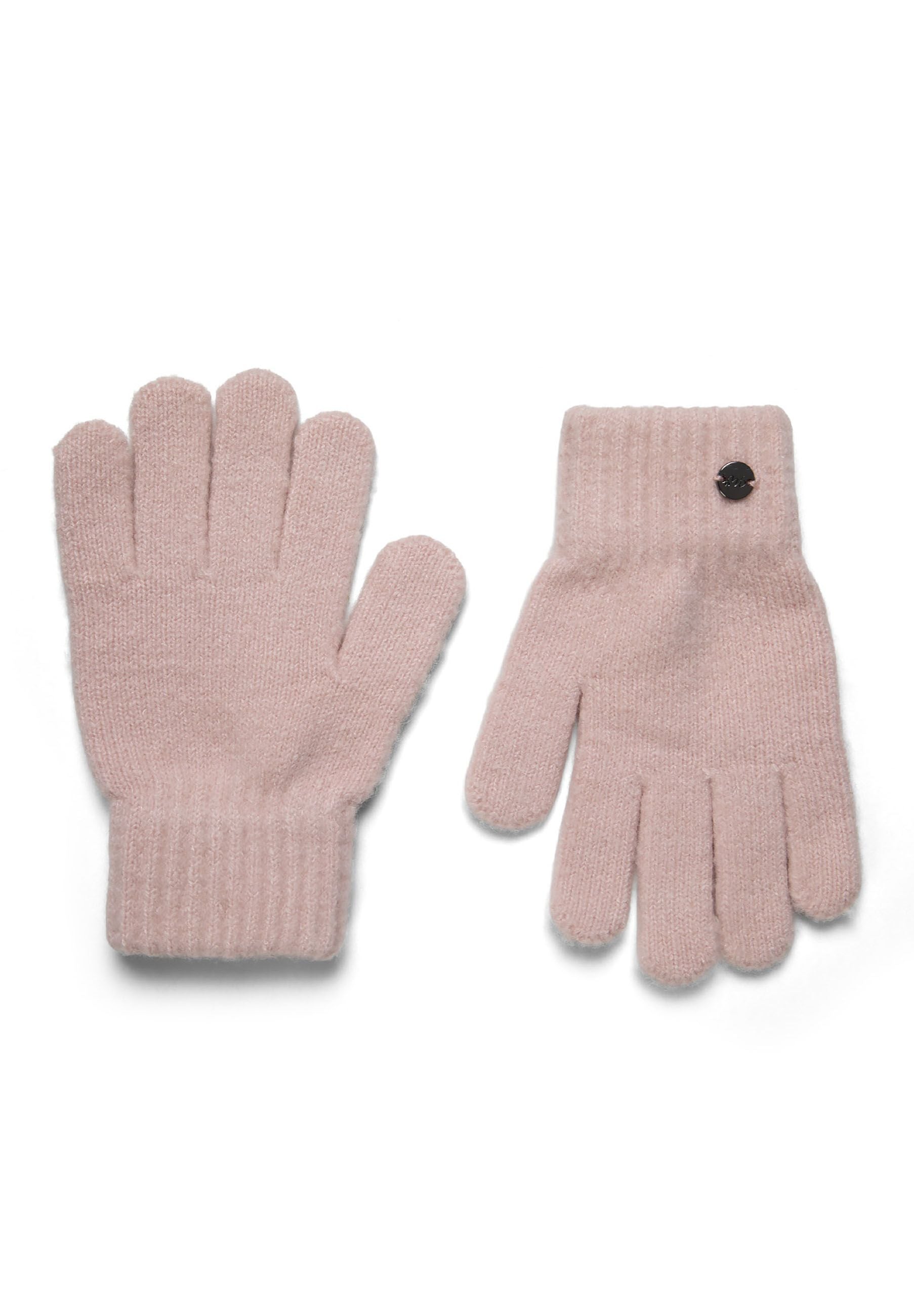 Detail of a pink ribbed knit hat with a metal badge.