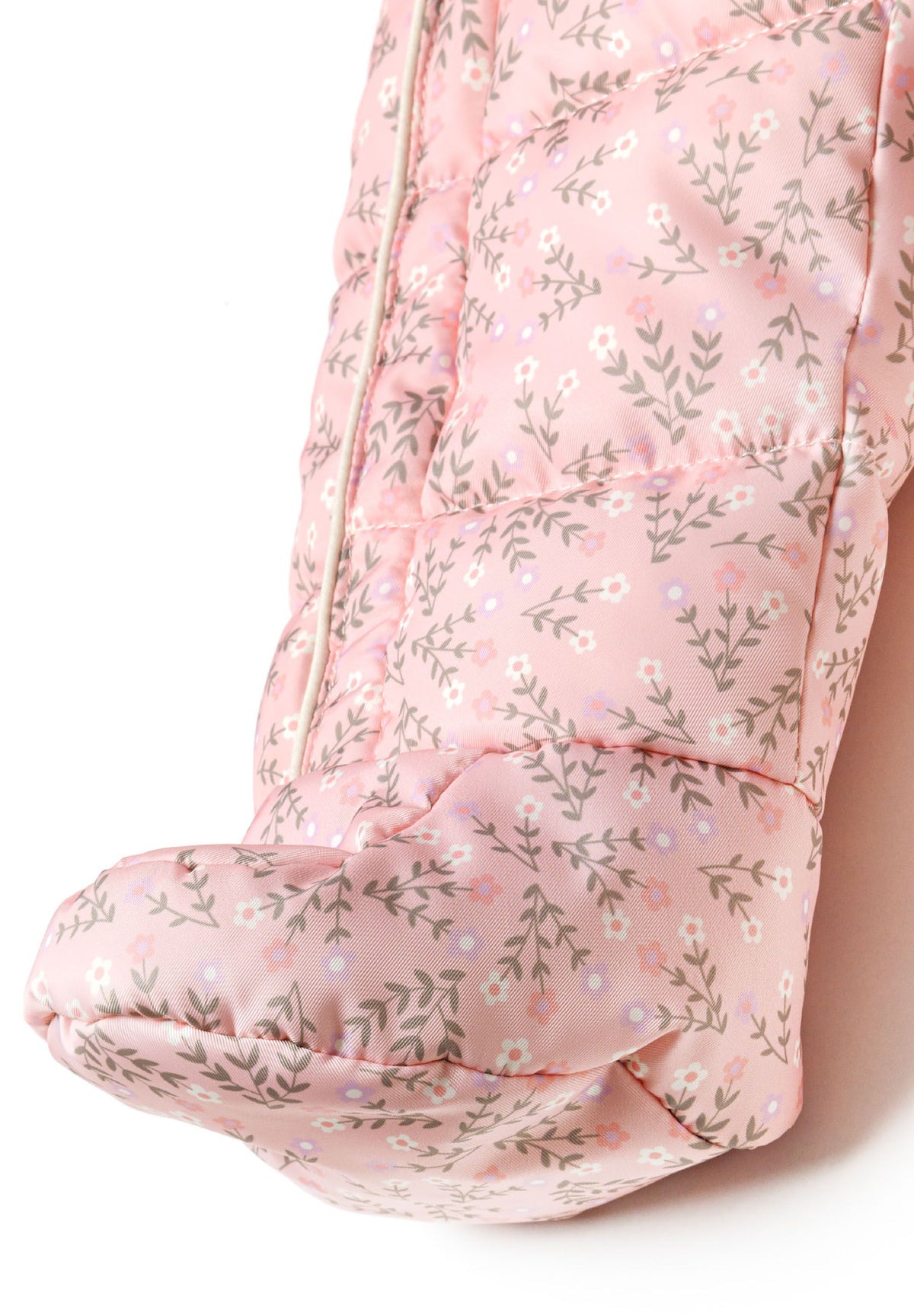 Detail of a light pink baby snowsuit with floral pattern, featuring a double zip and fold-back cuffs.