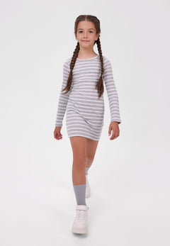 Girl wearing a short grey-and-white striped ribbed dress with long sleeves.