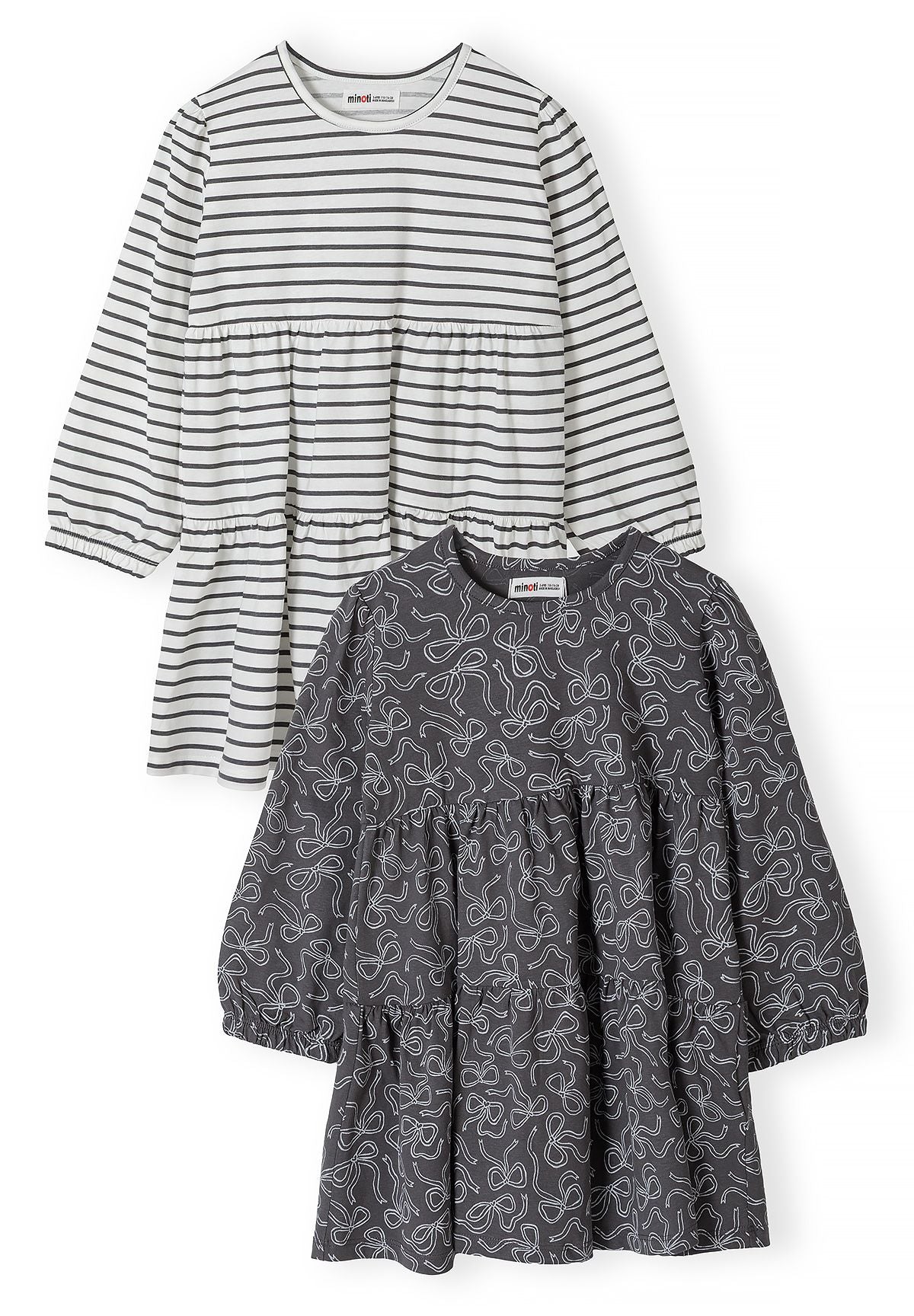 Front of two tiered dresses: charcoal bow print and white with grey stripes.