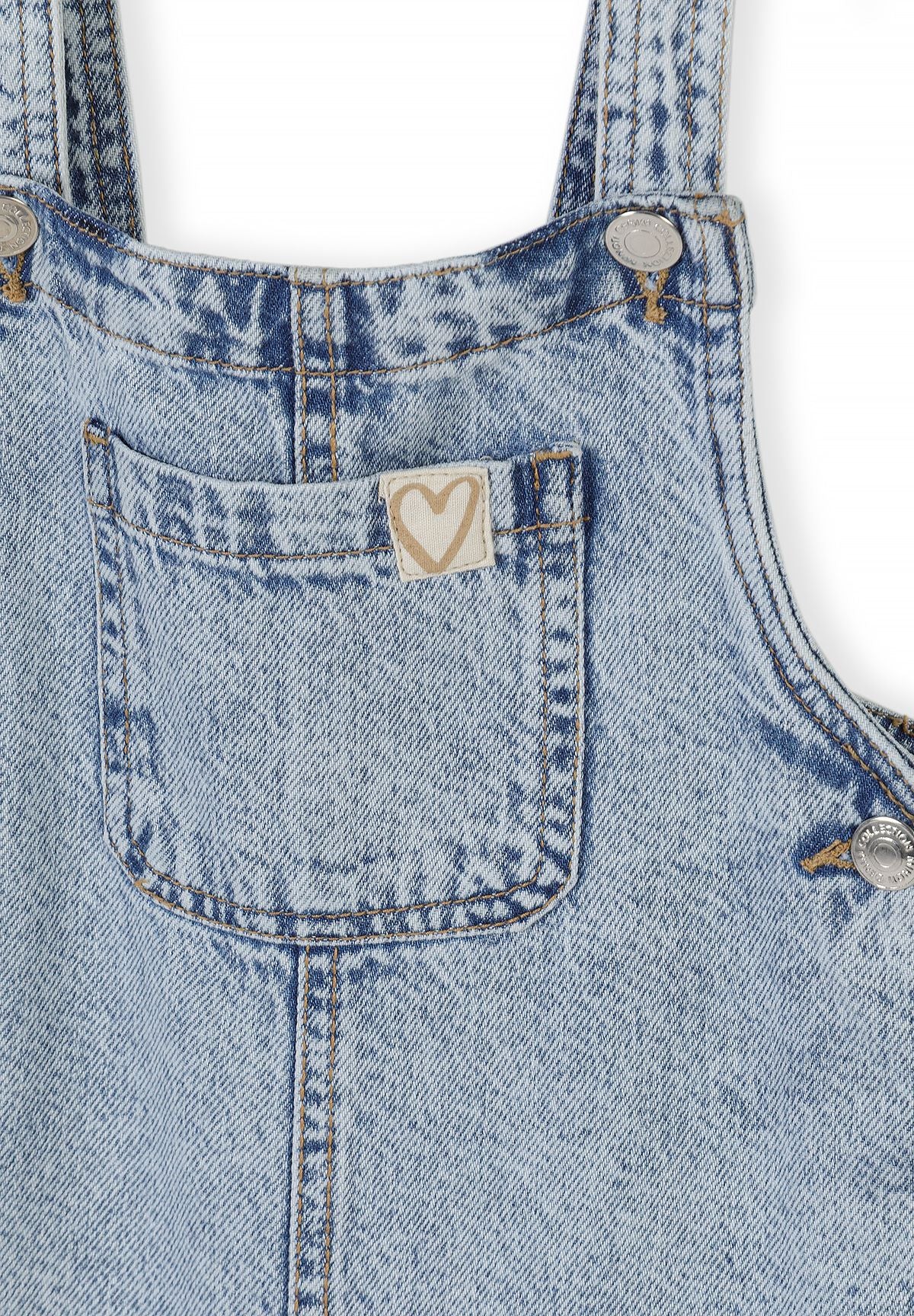 Lichtblauwe denim tuinbroek voor meisjes met verstelbare bandjes, detail van het borstzakje.