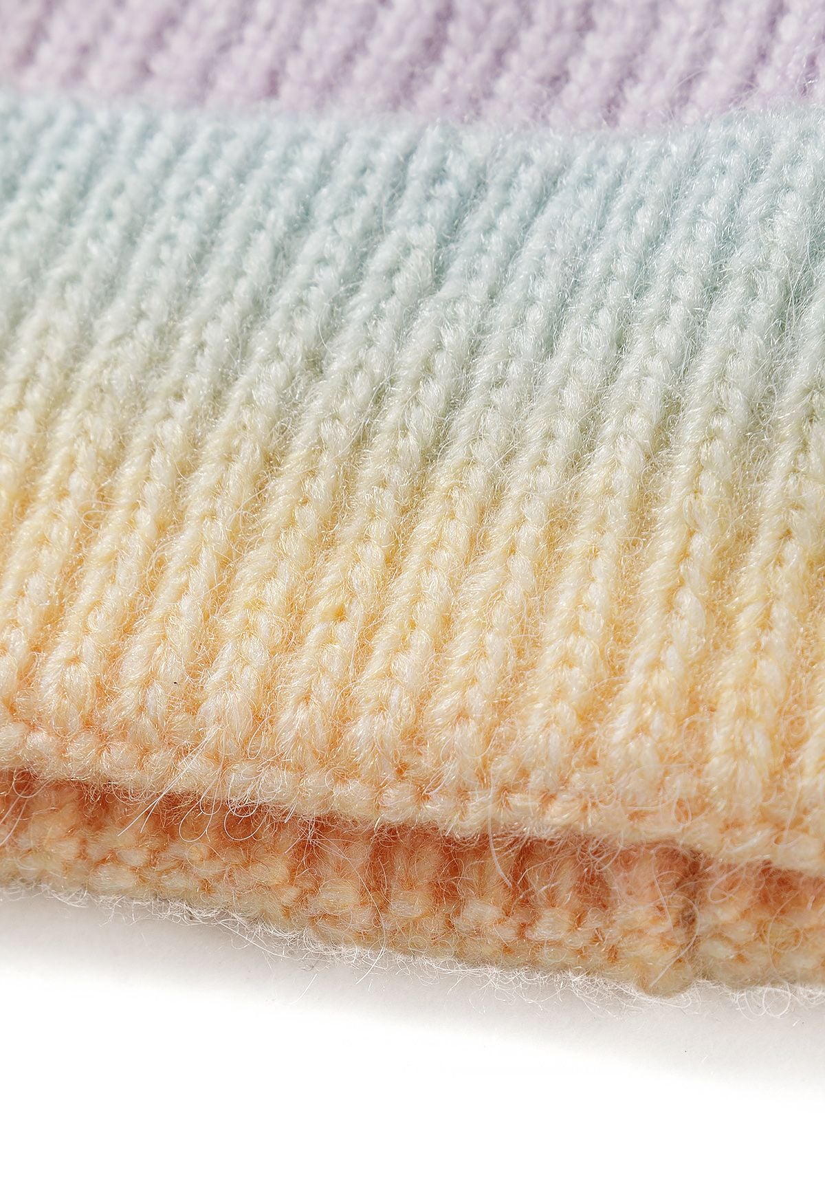 Close-up of fuzzy rib-knit scarf in pastel lilac, mint and yellow ombre bands.
