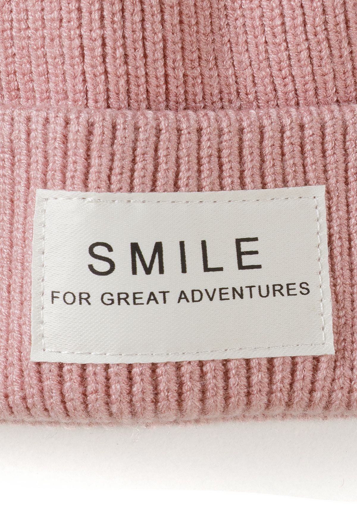 Gorro de punto acanalado para niña en color rosa palo y crema con insignia «Smile» (pack de 2), primer plano de la insignia «Smile».