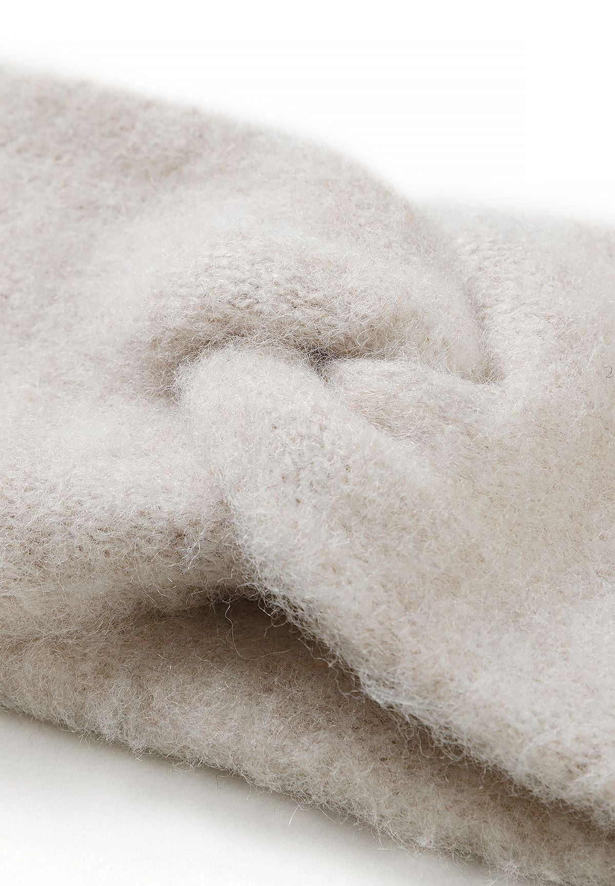 Close-up of the cream headband's crossed fuzzy knit front.