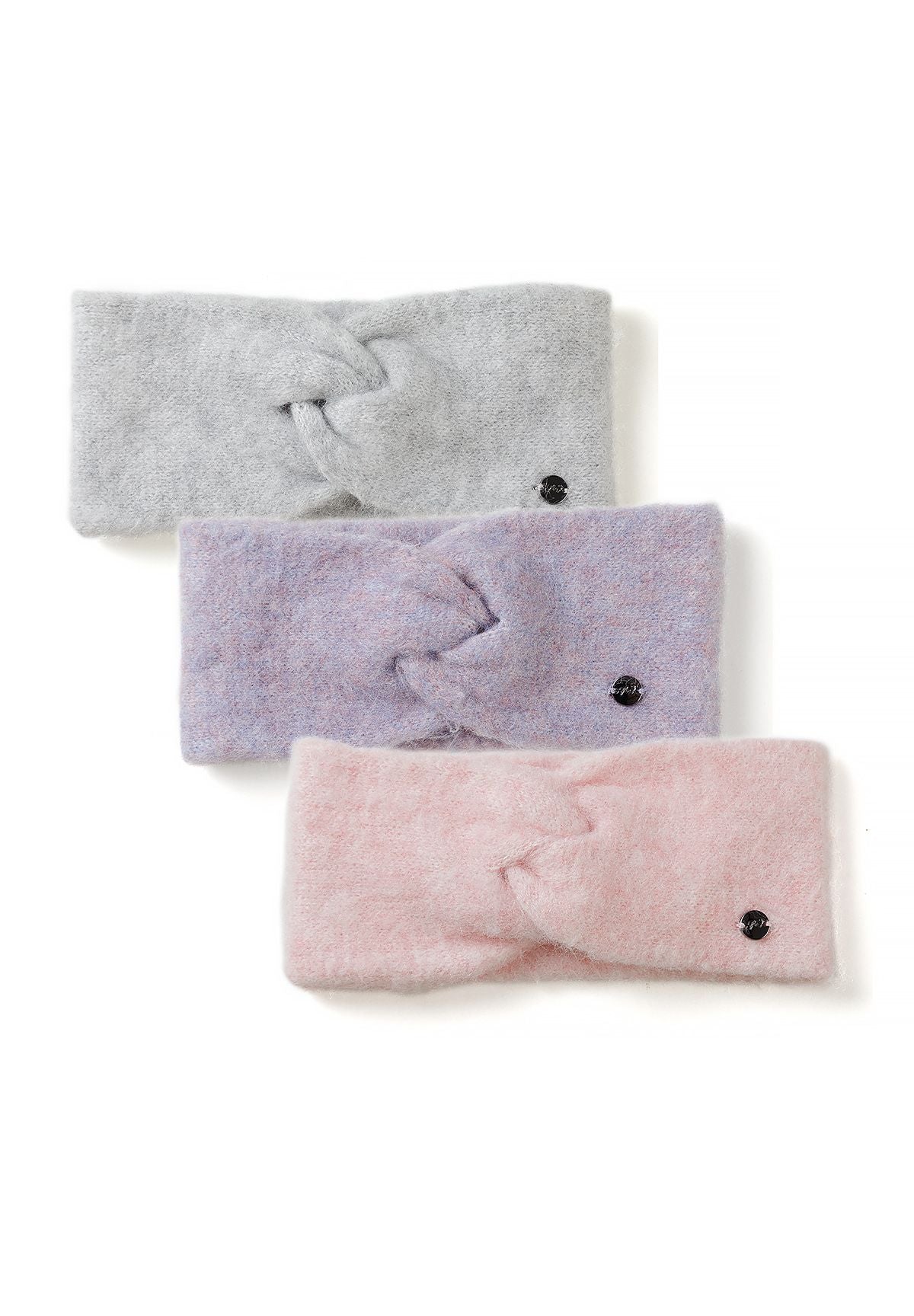 Three soft twist-front headbands in light grey, lilac and pale pink with small round badges.