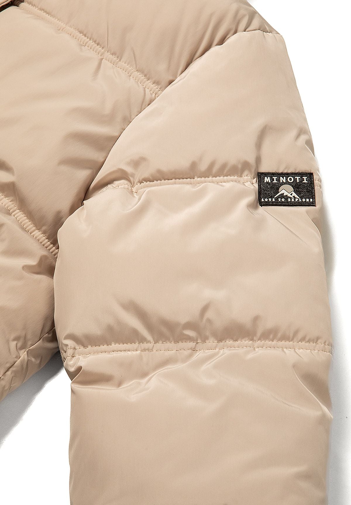Women's short puffer jacket in beige with hood, close-up of the Minoti badge on the sleeve