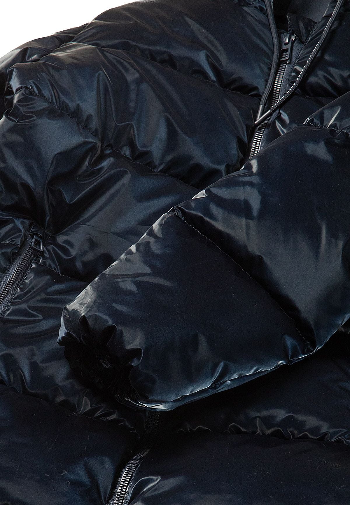 Close-up of a plain padded navy sleeve cuff against the glossy quilted coat front.