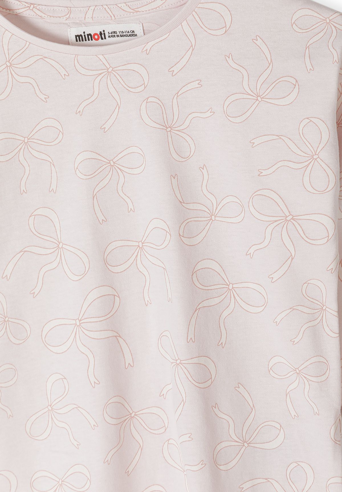 Close-up of fine outlined bows on pale pink top.