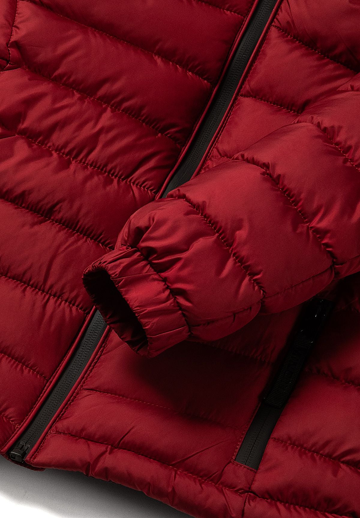 Close-up of the elasticated red sleeve cuff against the jacket's horizontal padding.