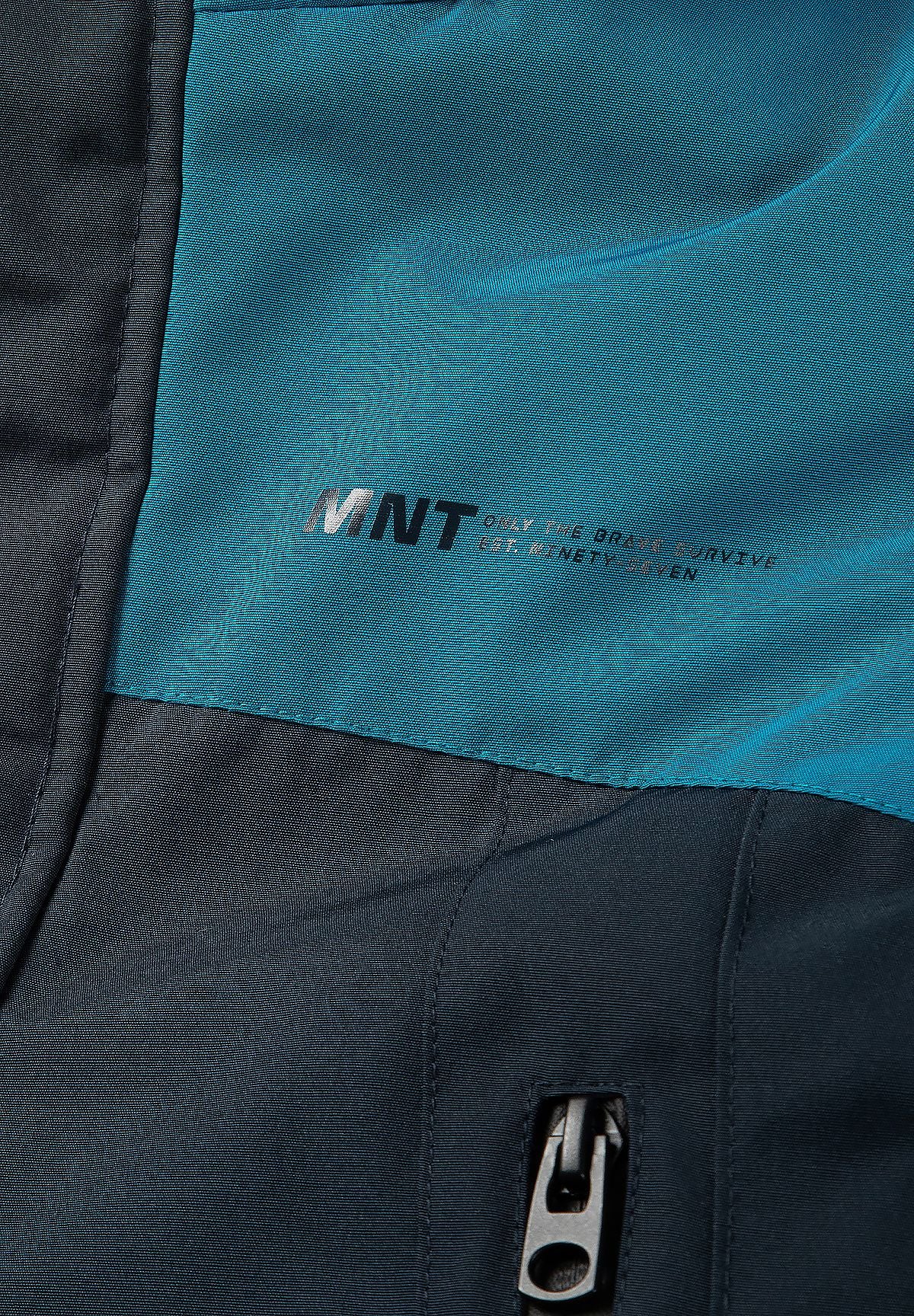 Small silver-toned MNT print on the teal chest above the parka's navy panel and pocket zip.