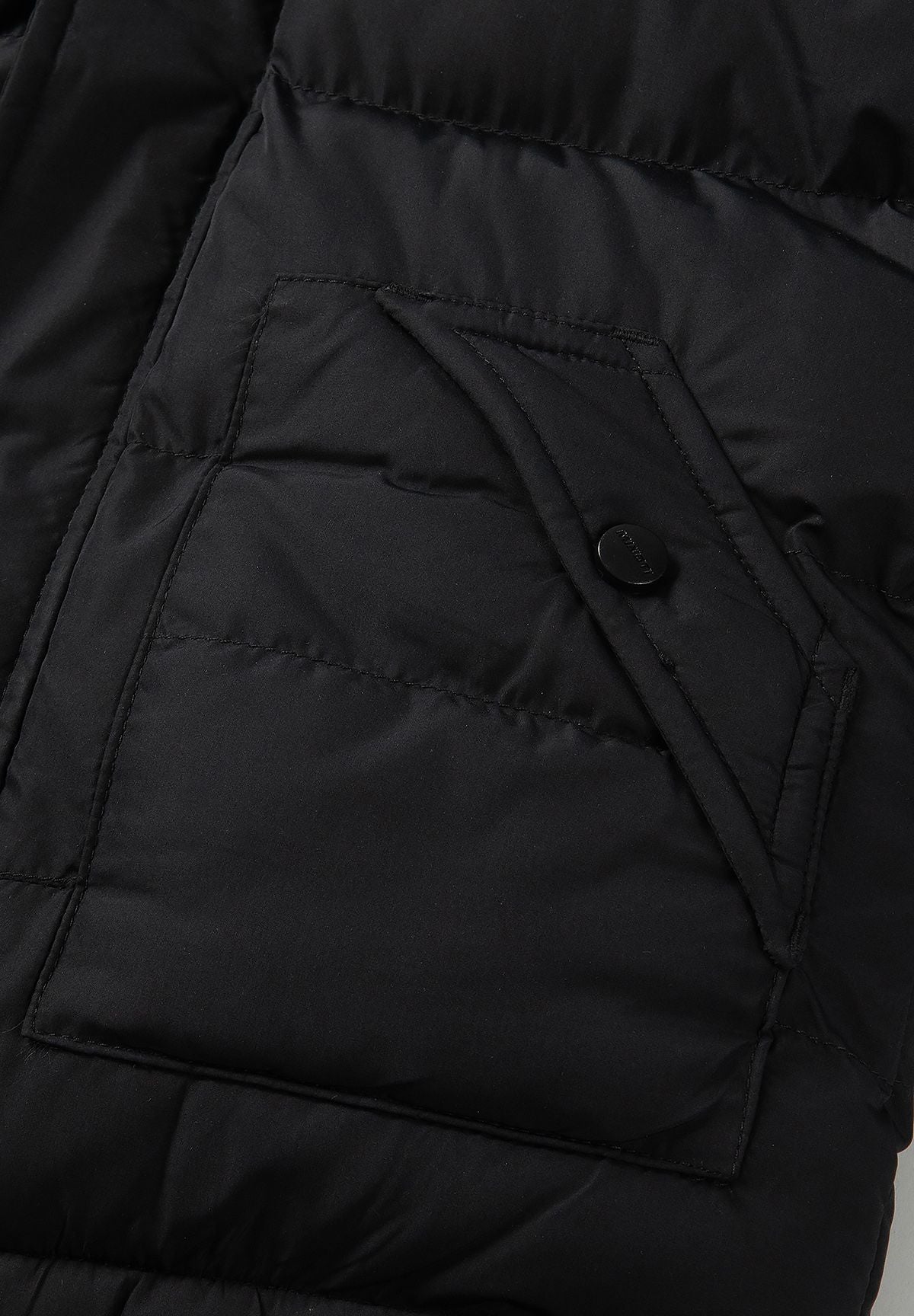 Zwarte gewatteerde parka voor jongens met afneembare capuchonrand, detail van de klepzak.