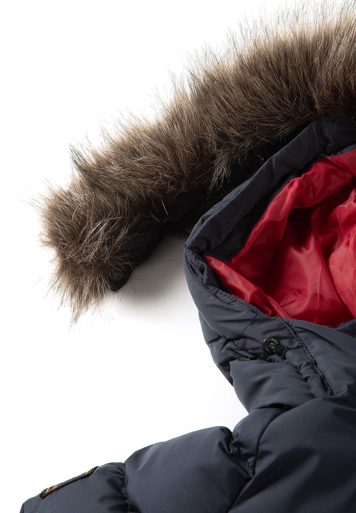 Donkerblauwe gewatteerde parka voor jongens met afneembare capuchonrand, detail van de capuchonrand van imitatiebont.
