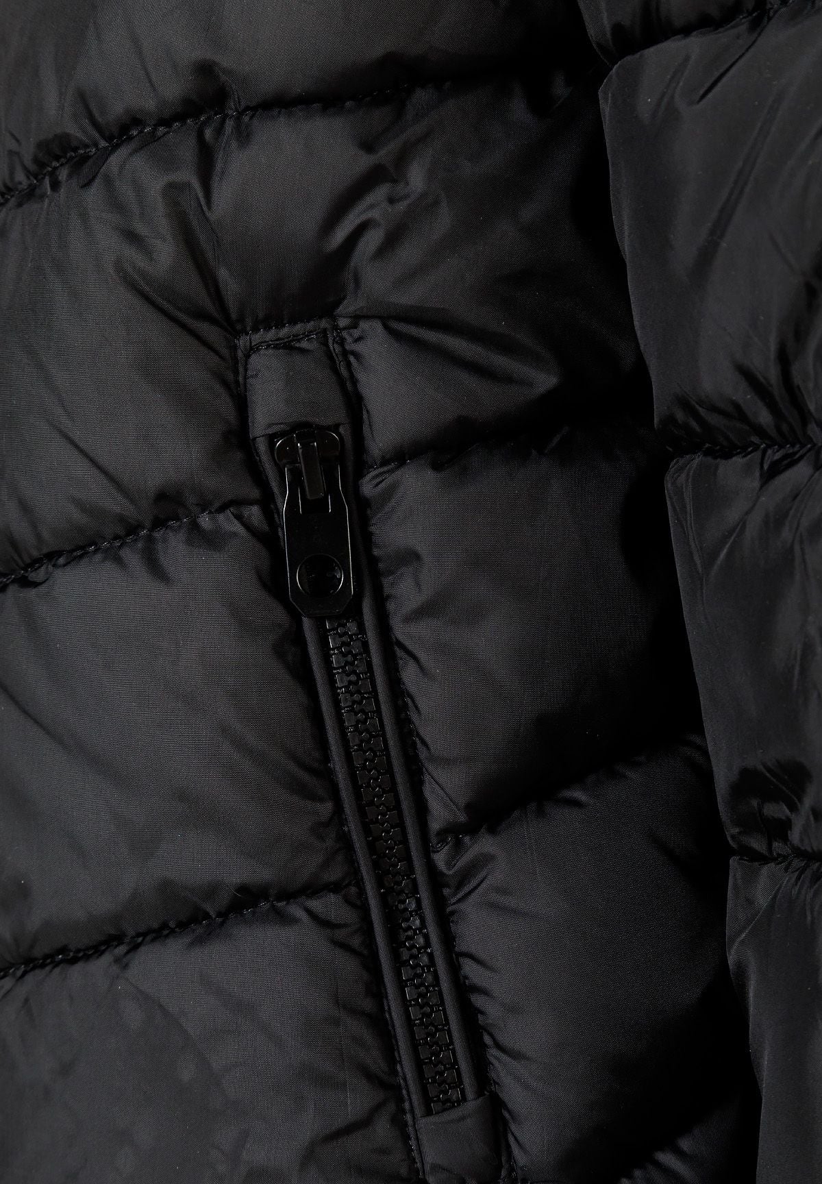 Close-up of a black vertical pocket zip between padded panels on the puffer jacket.