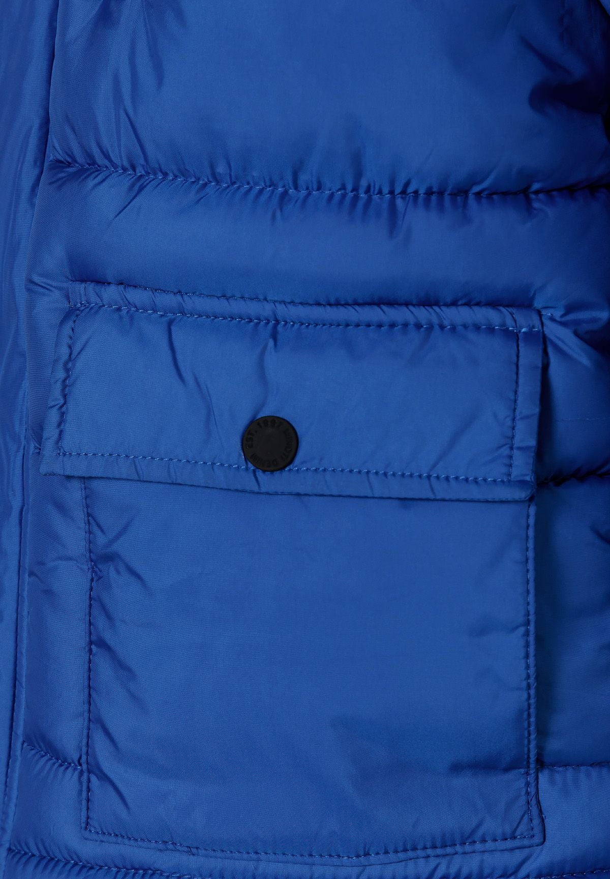Close-up of a large royal blue lower patch pocket with straight flap and black snap.