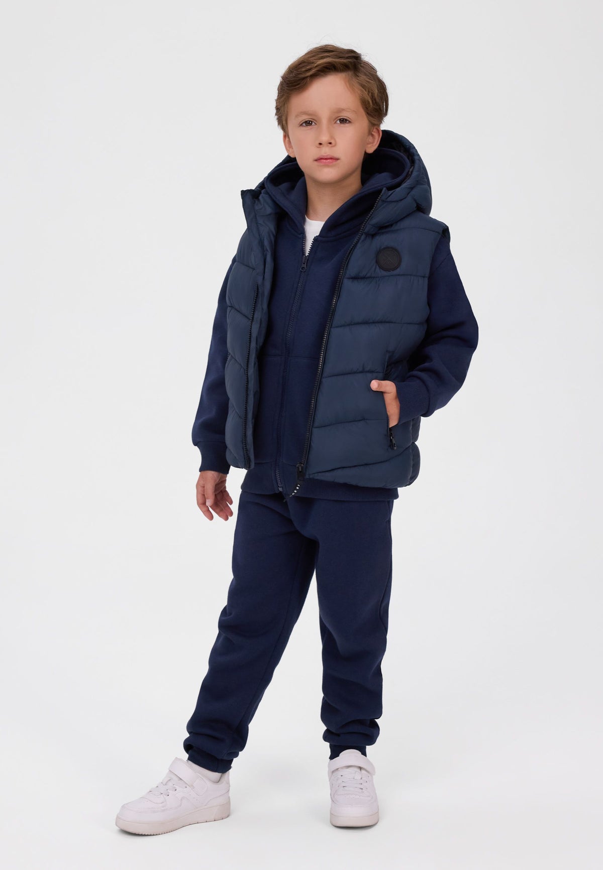 Wattierte Weste mit Kapuze für Jungen in Marineblau, Modell von vorne.
