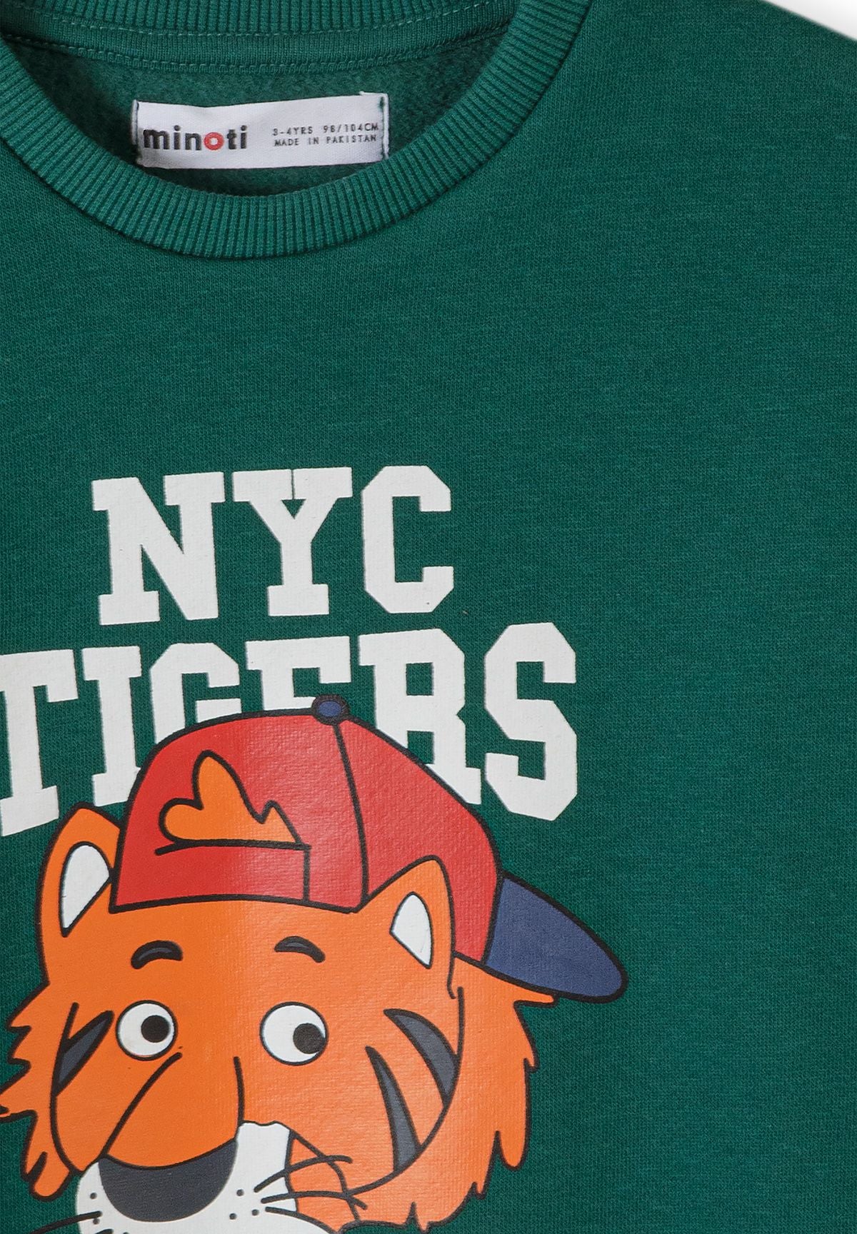 Green sweatshirt print detail showing white NYC Tigers text and orange tiger in a cap.