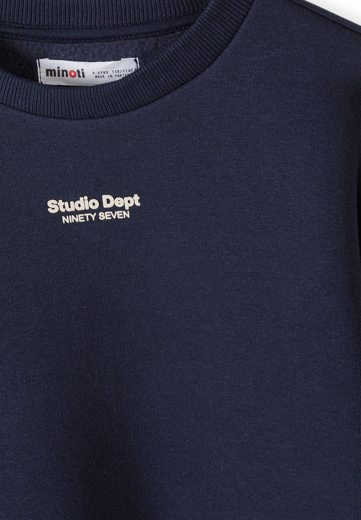 Navy sweatshirt close-up with white Studio Dept Ninety Seven chest lettering.
